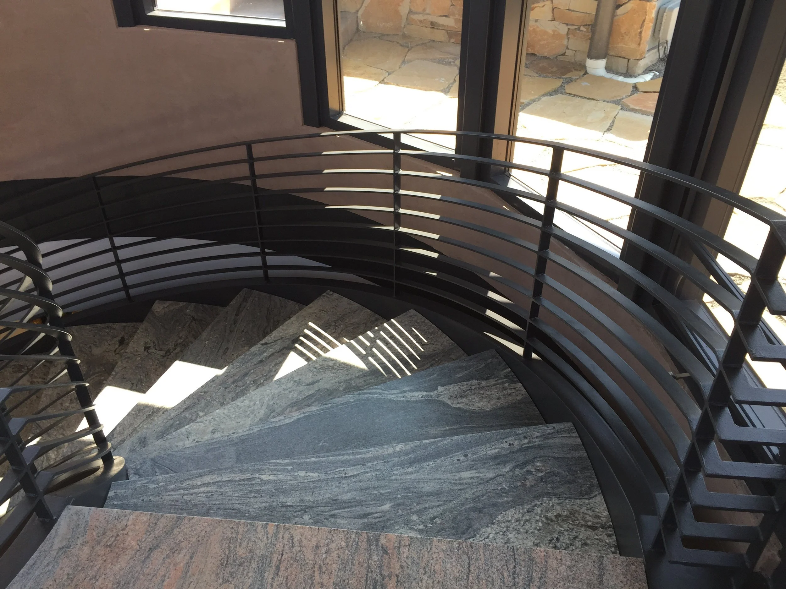 Custom steel stair wrapped in stone treads