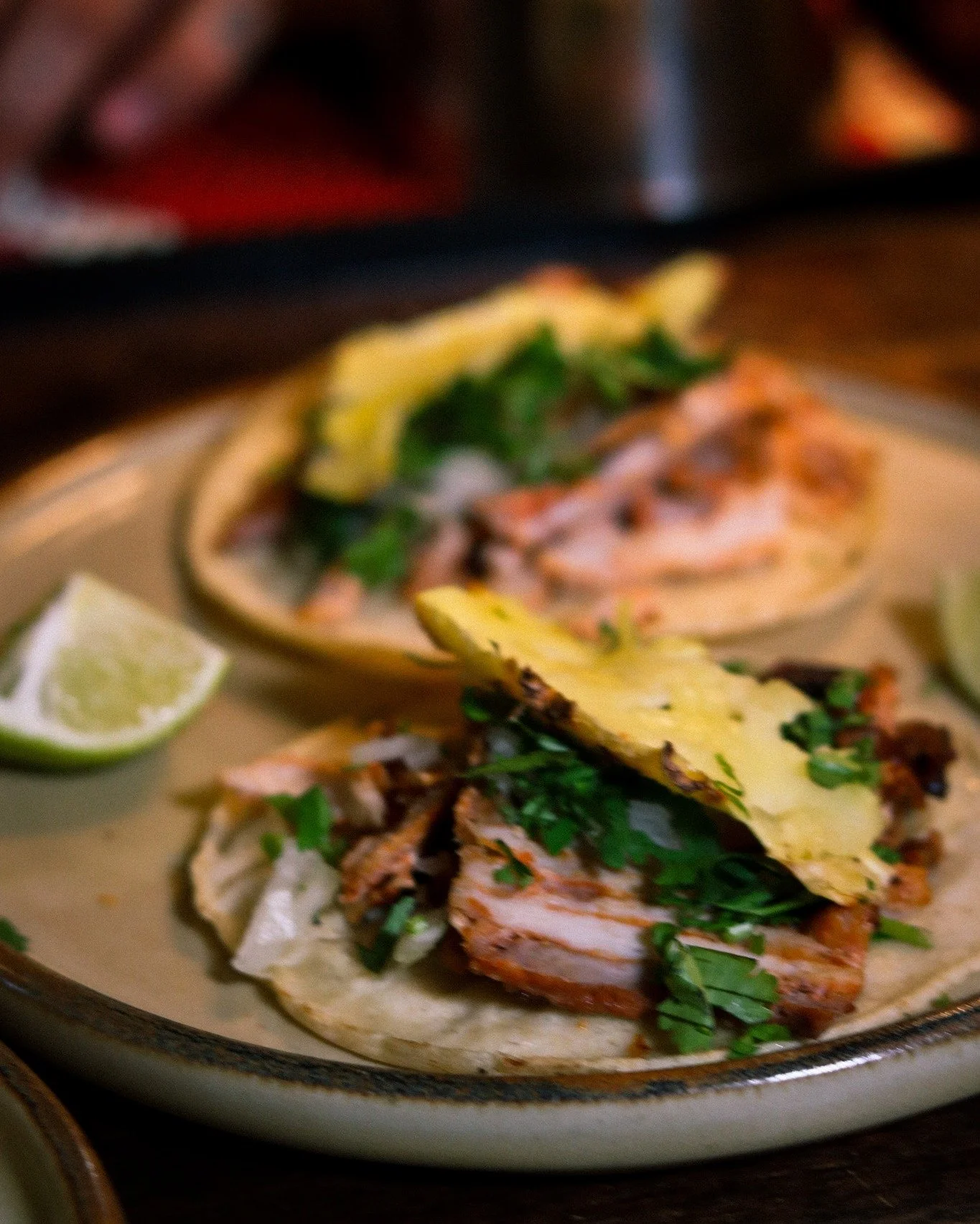 Al pastor isn't complete without the pi&ntilde;a on top.
That single slice of pineapple isn't decoration &mdash; it's tradition. Cut from the trompo, kissed by the same flame as the pork.
The sweetness cuts the adobo. The acid lifts the spice. Every 