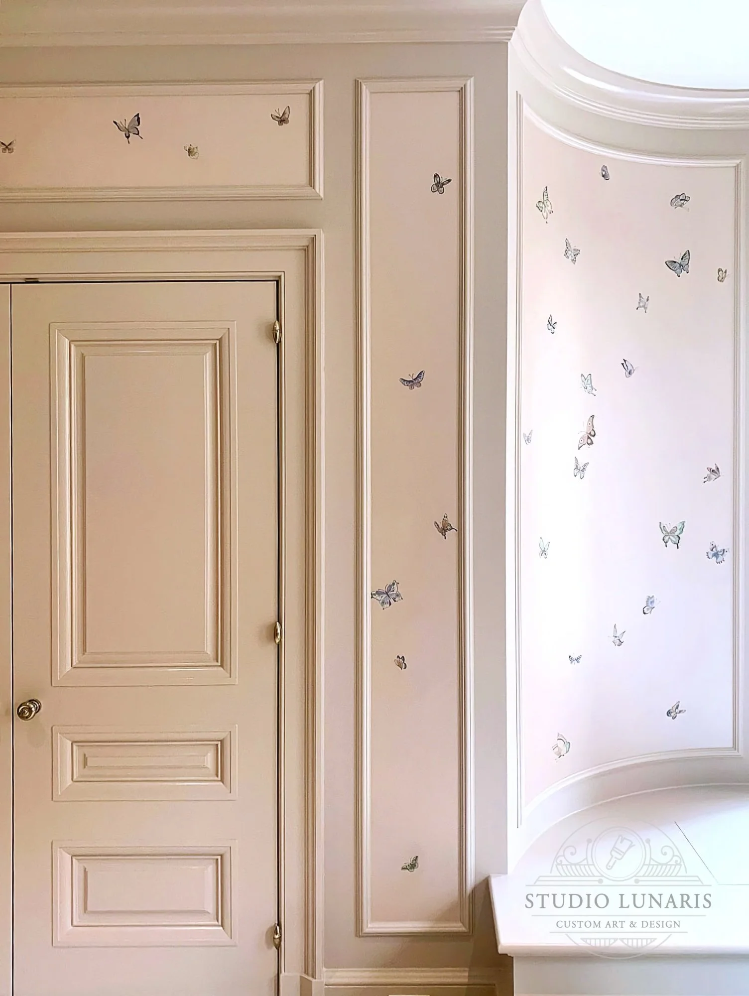 Nursery bedroom mural with a soft pink background and butterfly accents throughout.