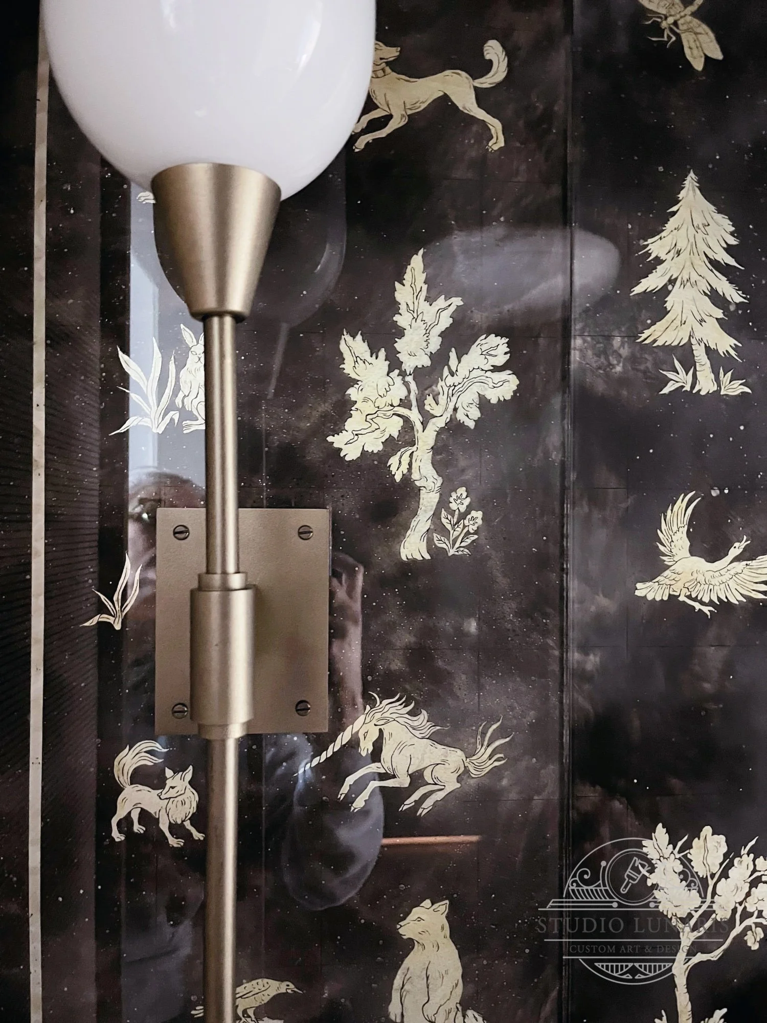 Entry foyer verre églomisé painted glass wall  panel close up with a forest themed silver accent elements - trees, plants, animals and insects