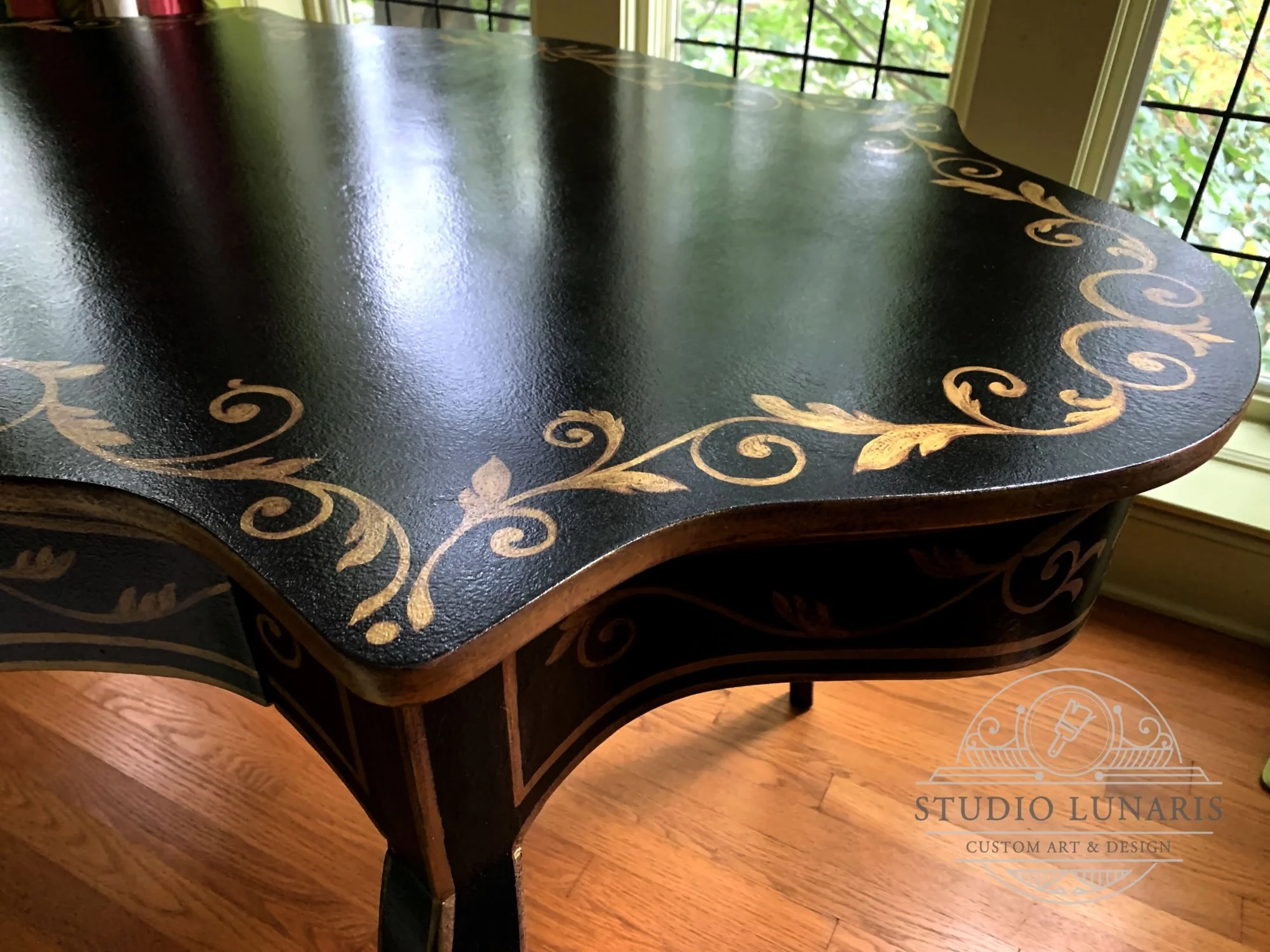 Writing desk with a faux Japanese black lacquer background and gold-painted, ornamental scroll pattern
