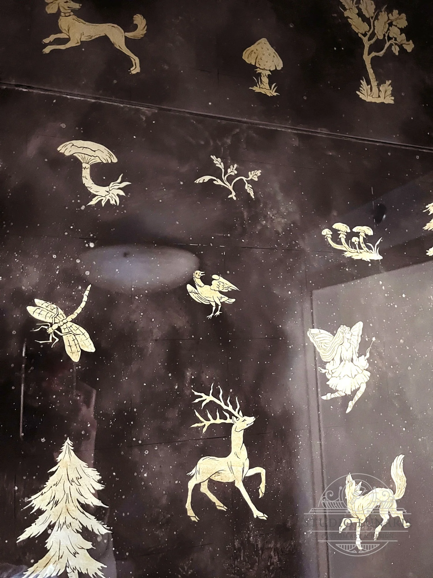 Entry foyer verre églomisé painted glass wall close up with a forest themed silver accent elements - trees, plants, animals, insects and fairies