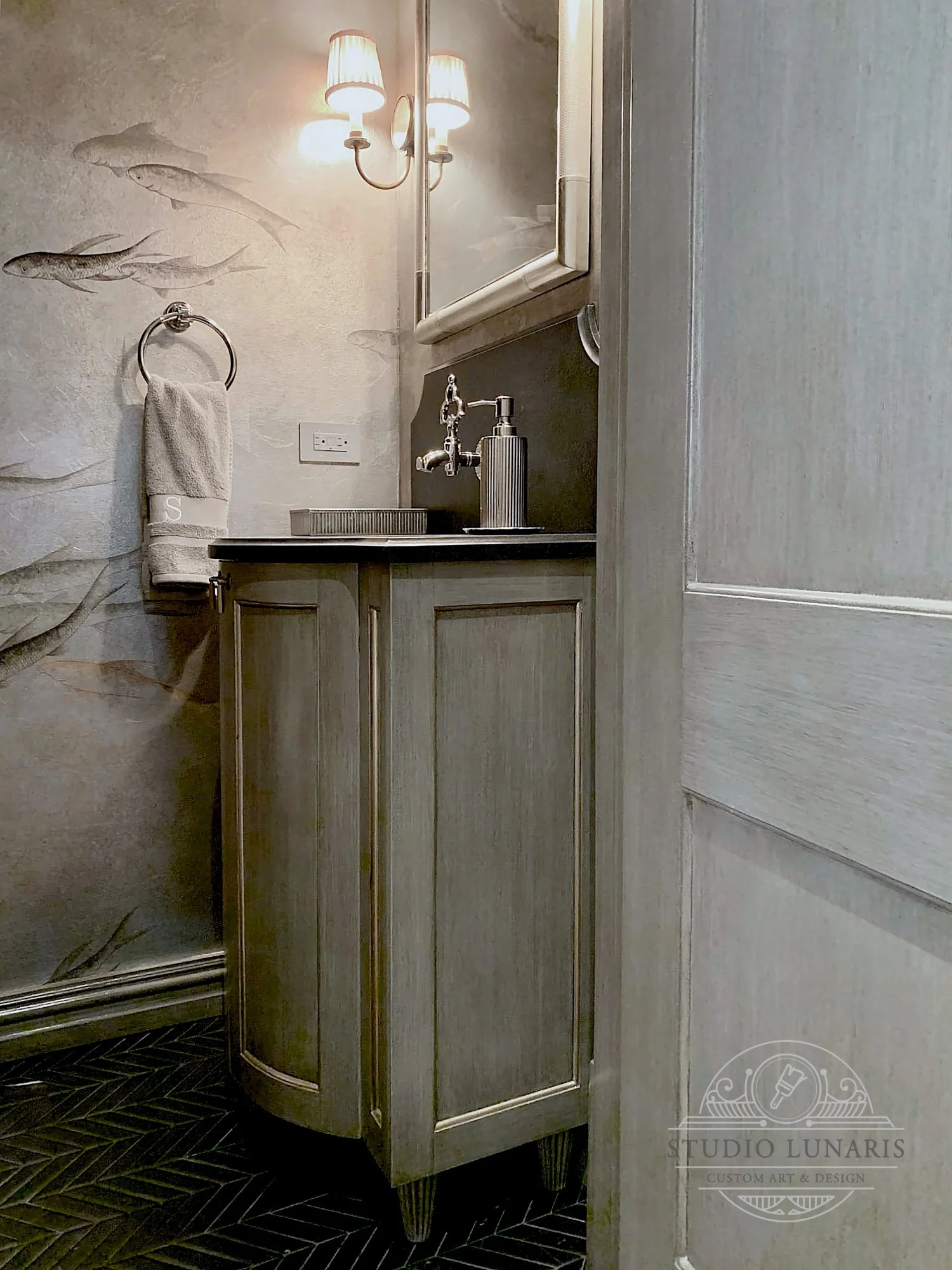 Powder room vanity and door with a striated grey background and metallic bead molding accents