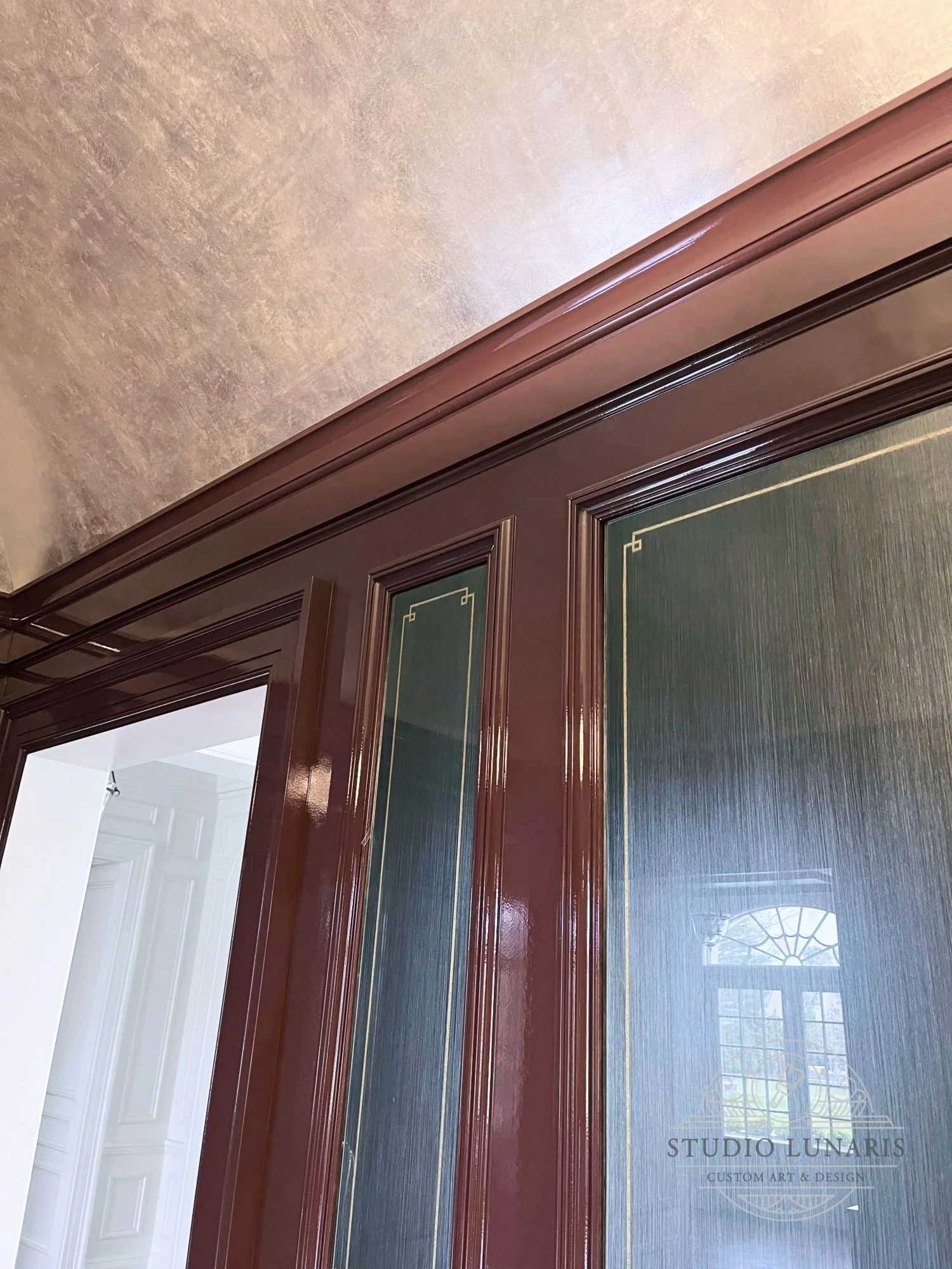 Wine room verre églomisé inset glass panels with a soft, pearlized blue striated background and gold metallic stripe pattern