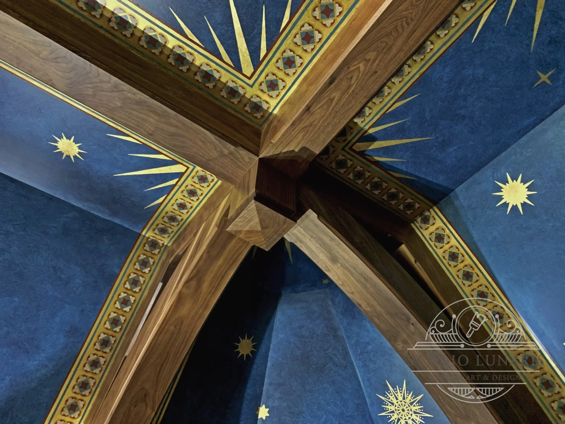 Gothic church inspired library ceiling mural, with an ornamental stencil pattern on a soft, dark blue background and gold metallic accents.