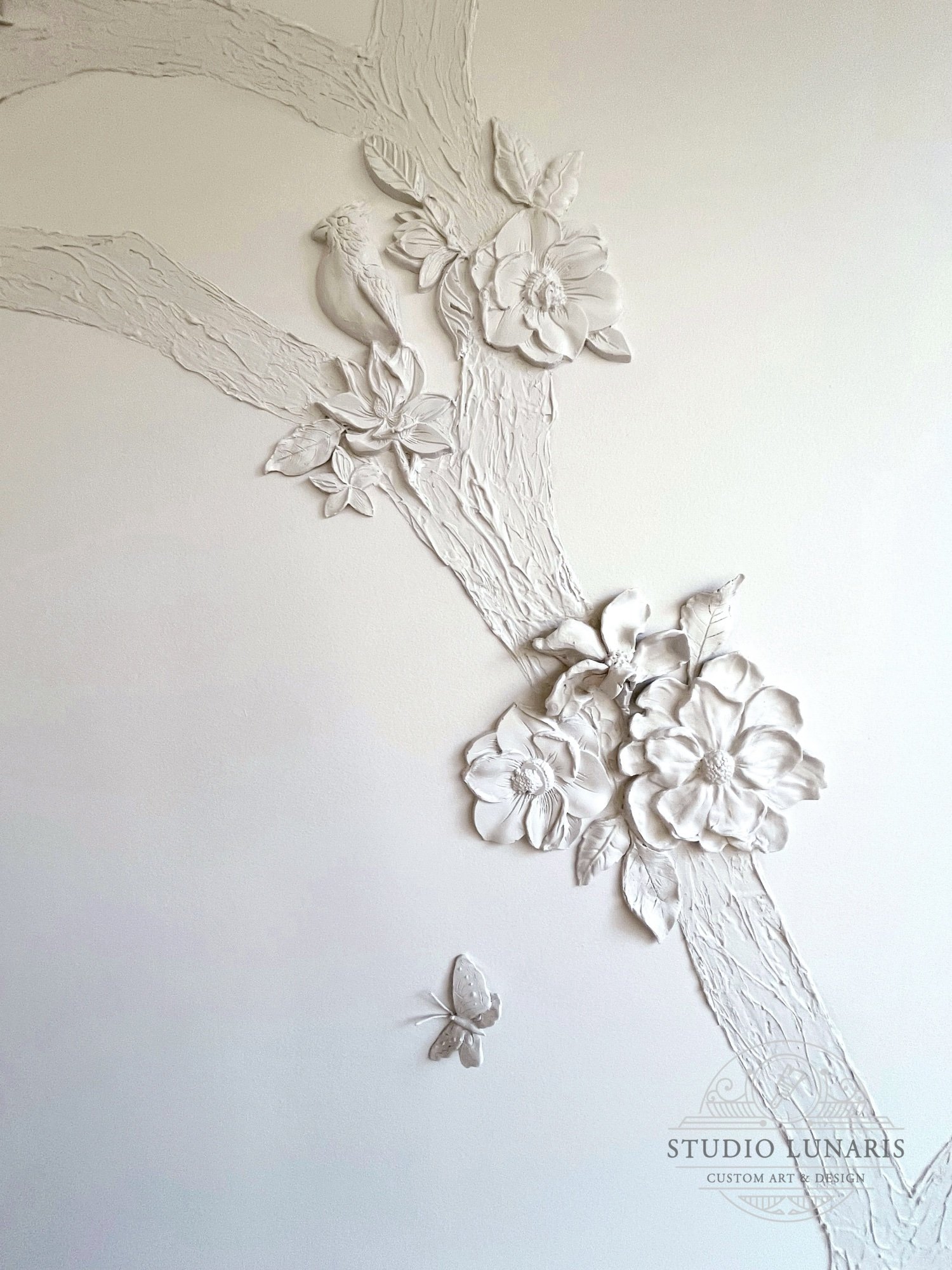 Bathroom mural detail with decorative plaster bas-relief tree and cast and hand-detailed floral and bird elements. 