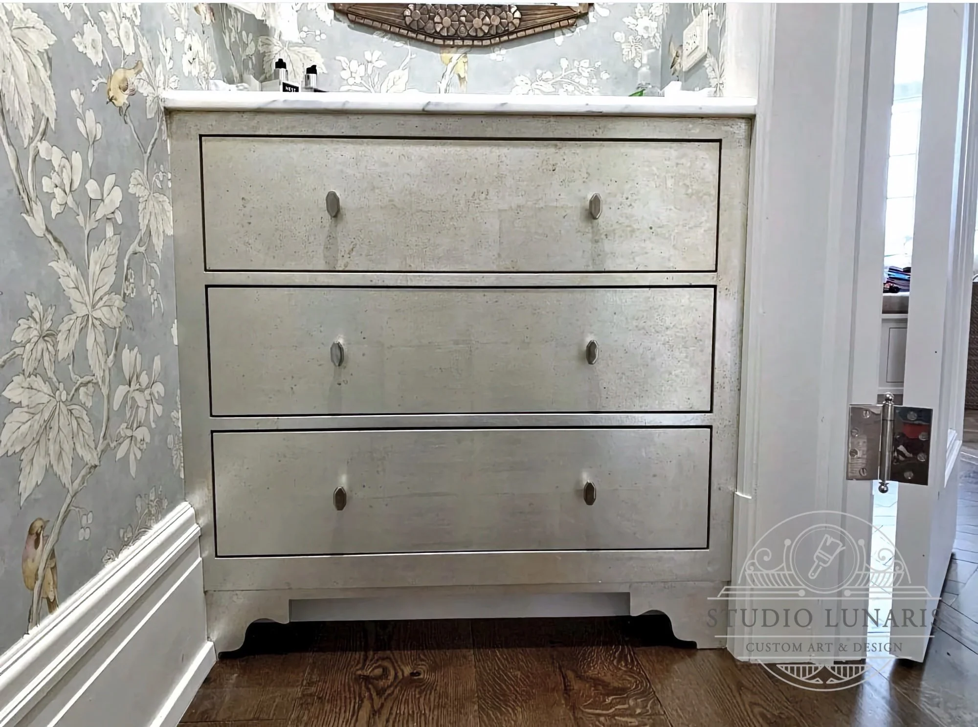 Powder room vanity cabinet with a silver leaf patina