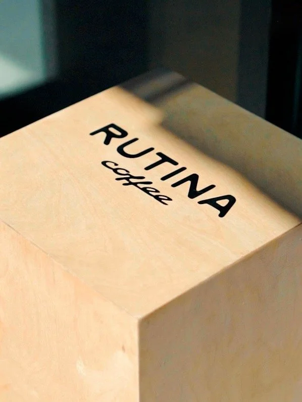 Nameplate on a wooden box that reads 'RUTINA coffee'.