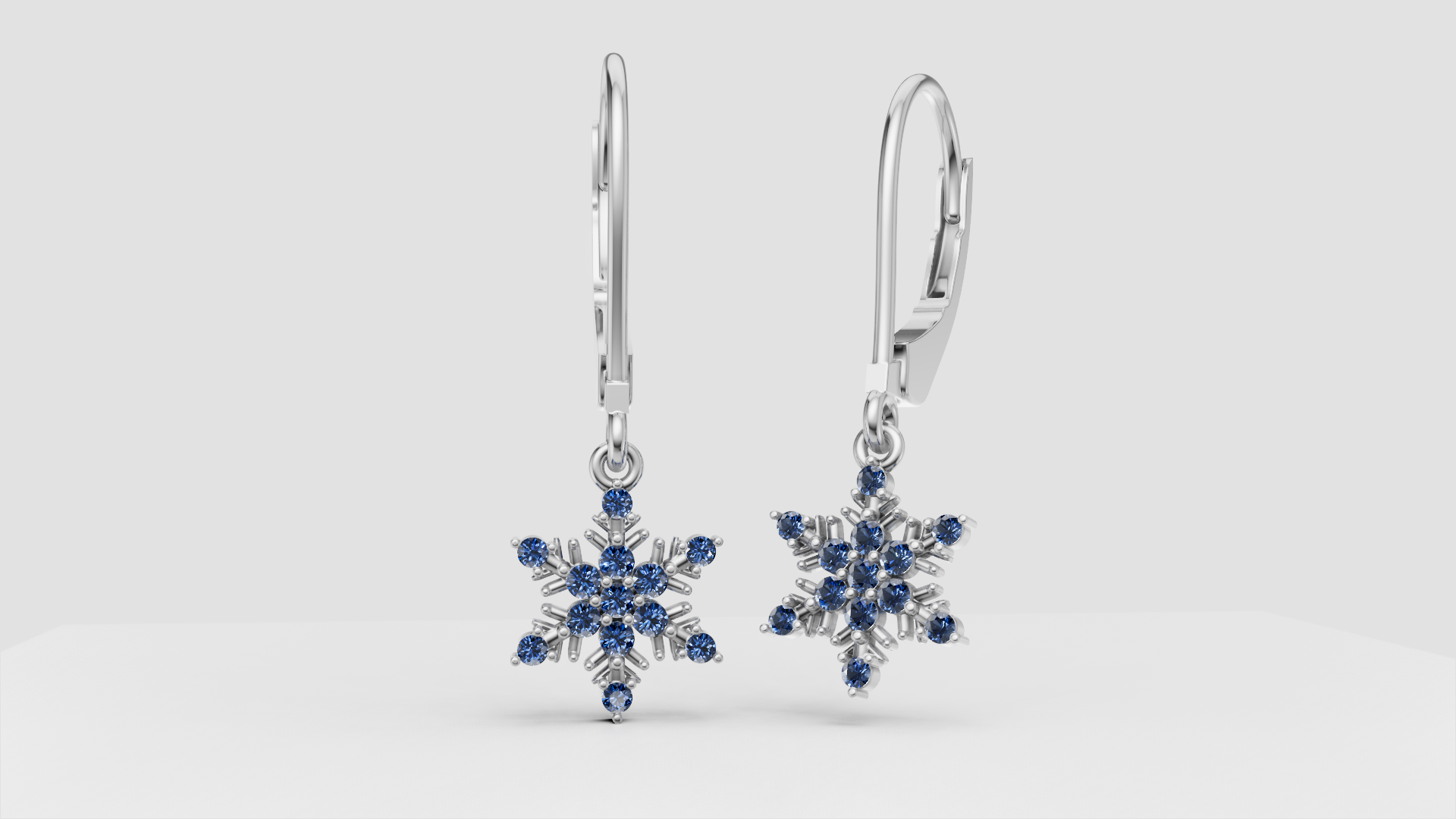 Silver earrings with snowflake-shaped pendants adorned with blue gemstones.
