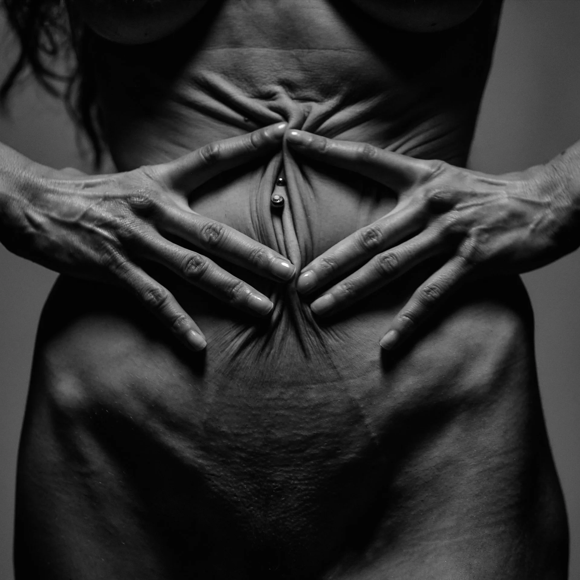 Une femme nue tenant ses seins avec ses mains forme un dessin en forme de cœur.