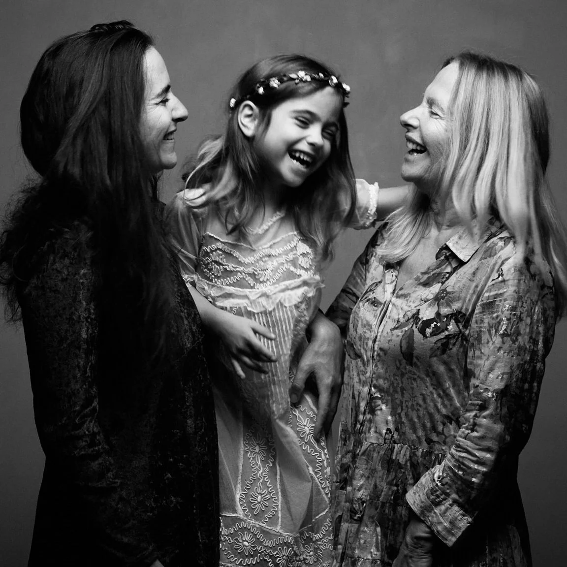 Trois femmes et une jeune fille en train de rire et de partager un moment heureux.