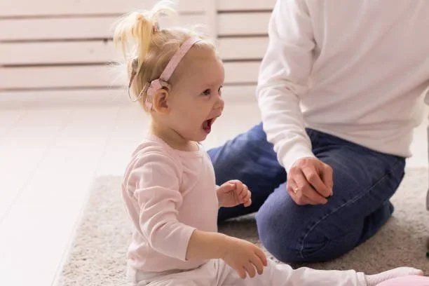 Little girl with cochlear implants playing during Auditory Verbal Therapy session with Little Ears, Big Voices in Orange County, CA
