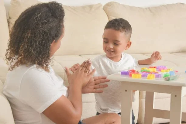 Mother and child playing with blocks during virtual parent coaching session with Little Ears, Big Voices in Orange County, CA.
