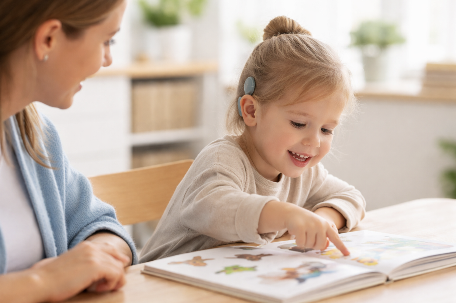Child with cochlear implant engaged in a book with adult during Auditory Verbal Therapy at Little Ears, Big Voices in Orange County, CA.
