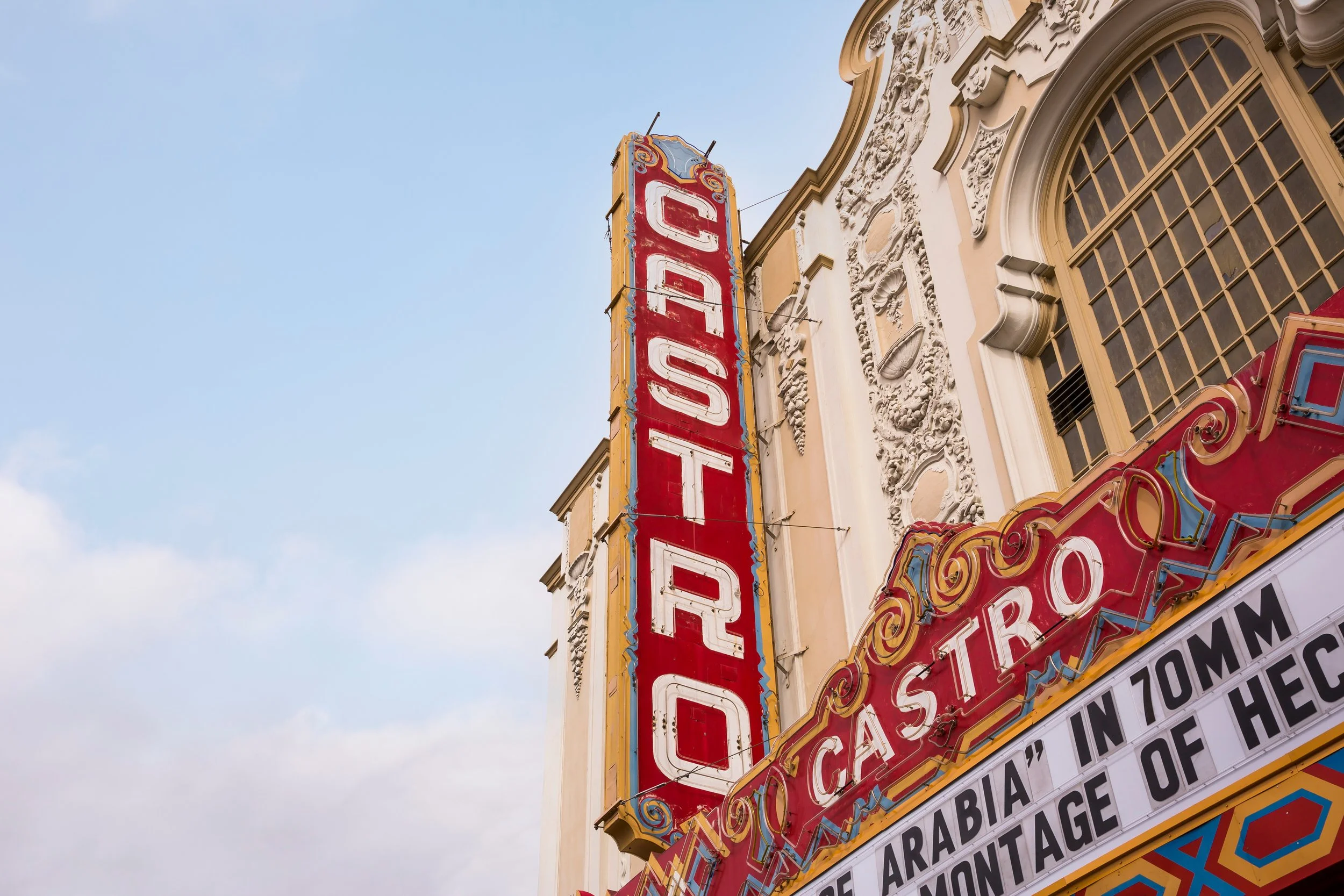 Vintage theater sign reading 'OTO CO' on a building with ornate architectural details against a blue sky.