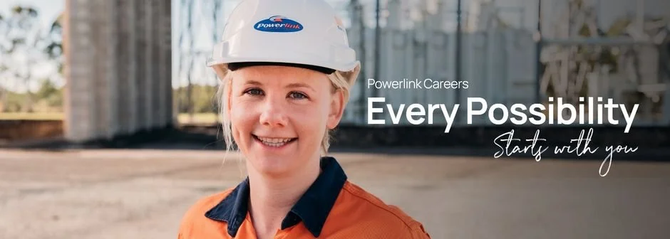 A smiling woman in construction gear, including a hard hat with Powerlink branding, outdoors with a construction site in the background, with text overlaid saying 'Powerlink Careers Every Possibility Starts with you'.