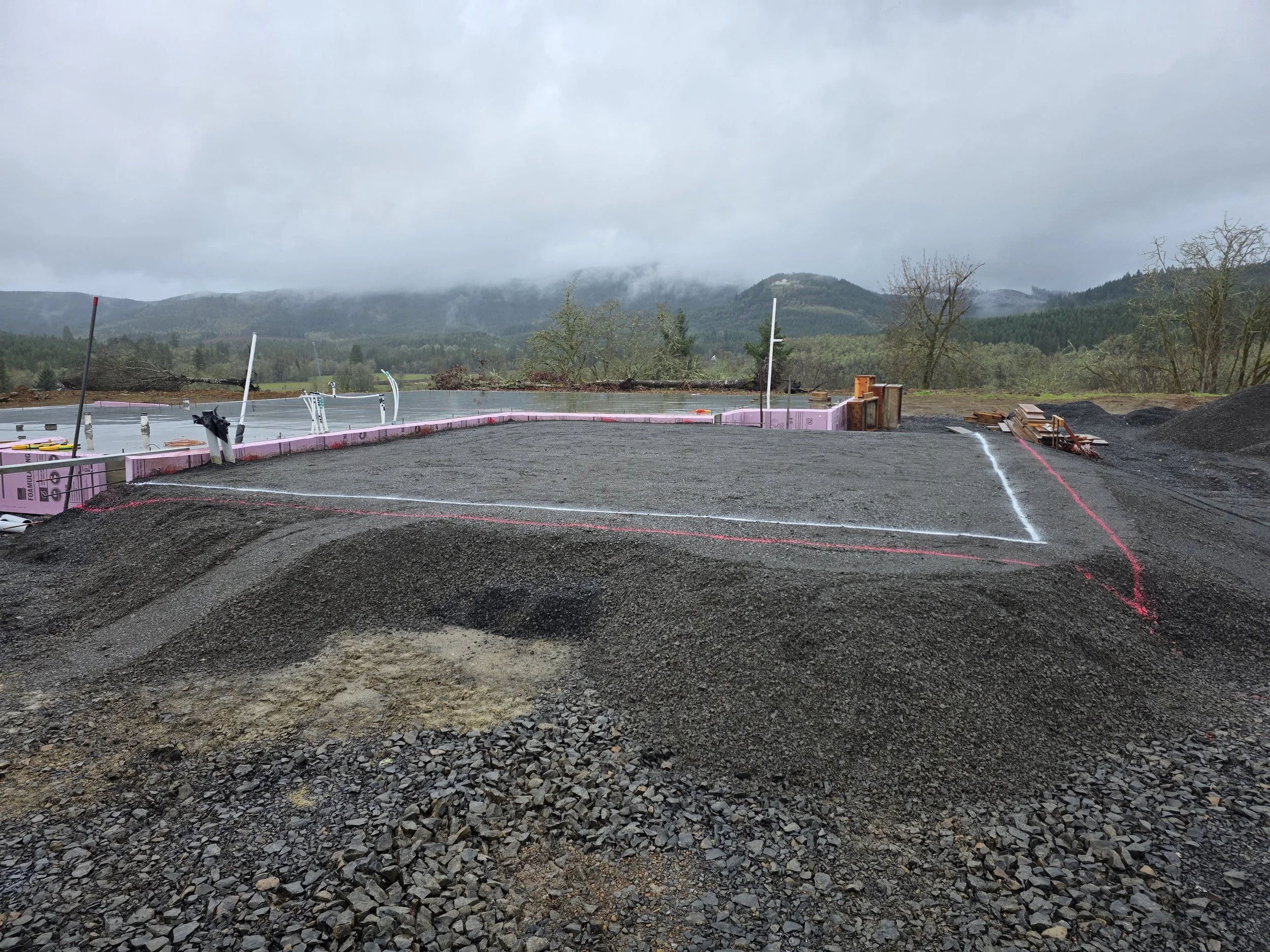Construction site with foundation being prepared in a mountainous area on a cloudy day. New House dig out Salem Oregon