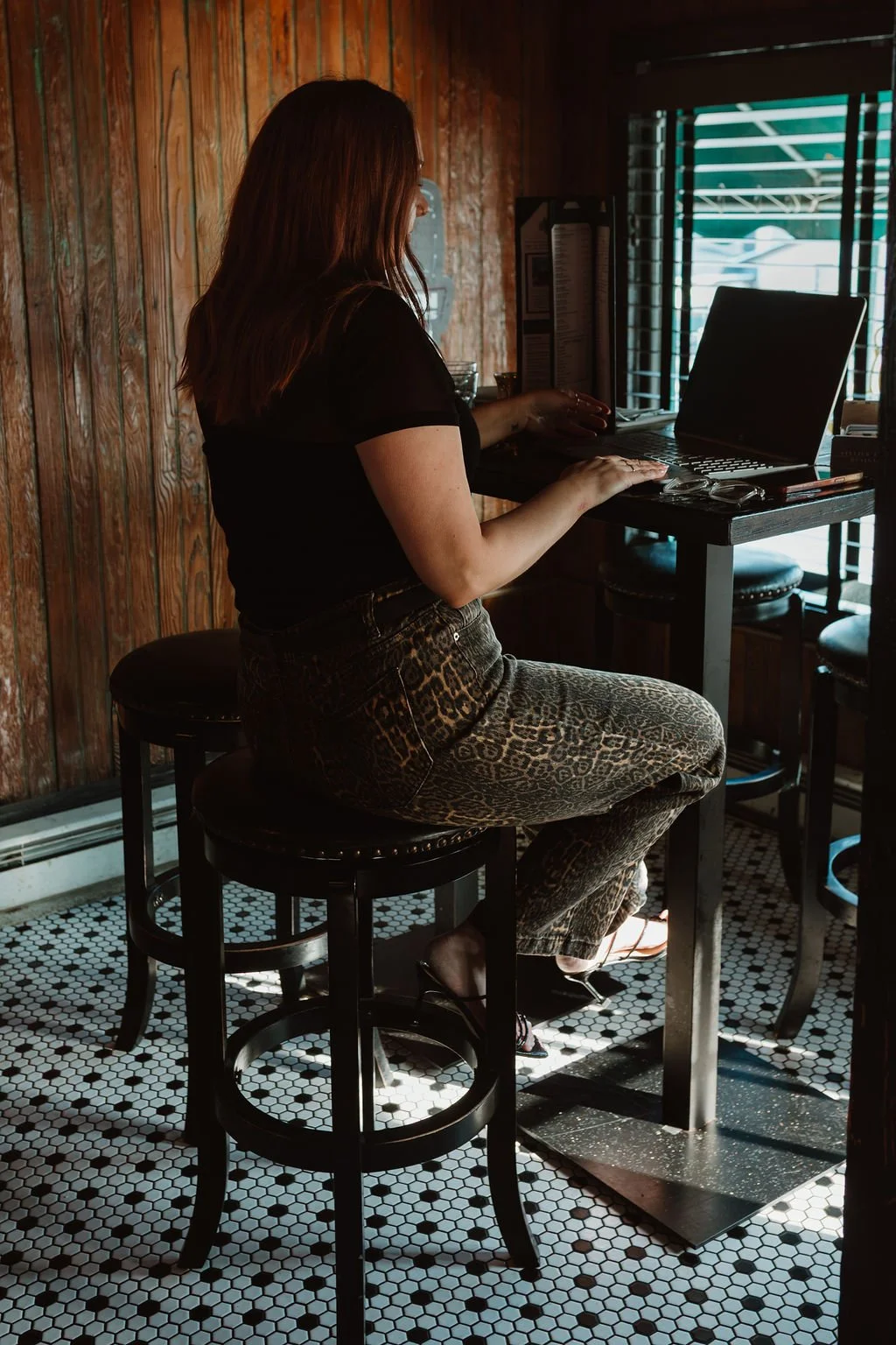 April, owner of Atelier Haus in Westminster, MD, working on a laptop creating a modern website for Carroll County clients.