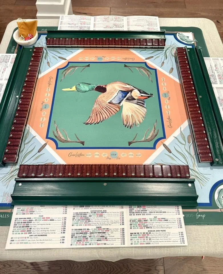 Charleston Mahjong Club Hunt Club tiles on the Mahjong Moxie Duck Camp mat with dark wood racks