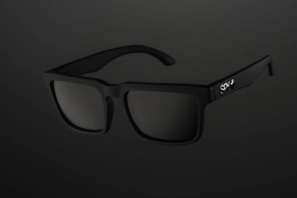 Black sunglasses with reflective lenses on a dark background.