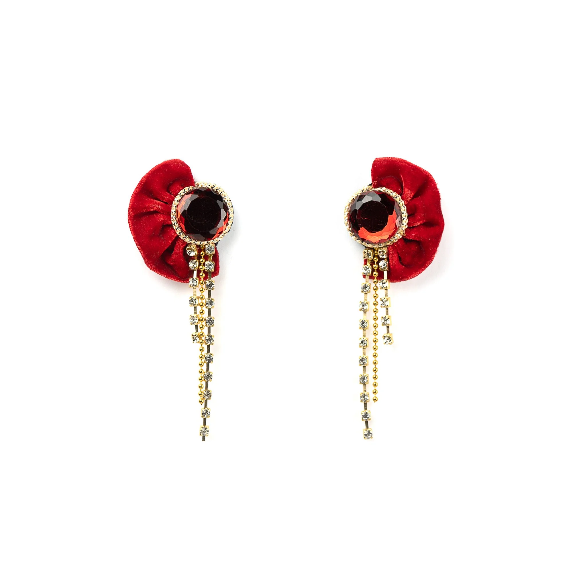 Elegant earrings featuring large red gemstones, surrounded by gold and rhinestones, with red velvet fabric accents and dangling rhinestone chains against a white background.