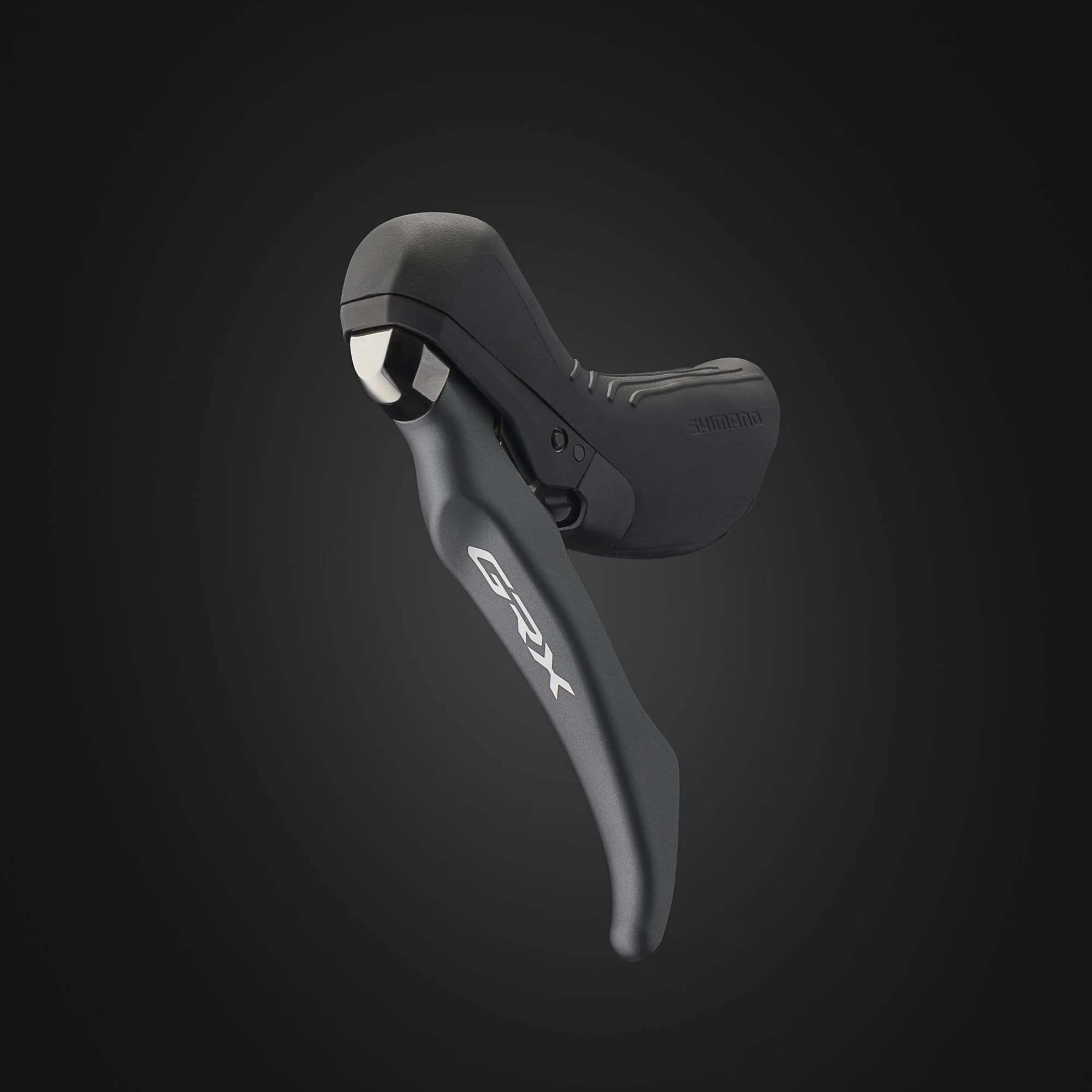 Close-up view of a modern bicycle gear shifter with a black handle and Shimano branding, isolated on a dark background.