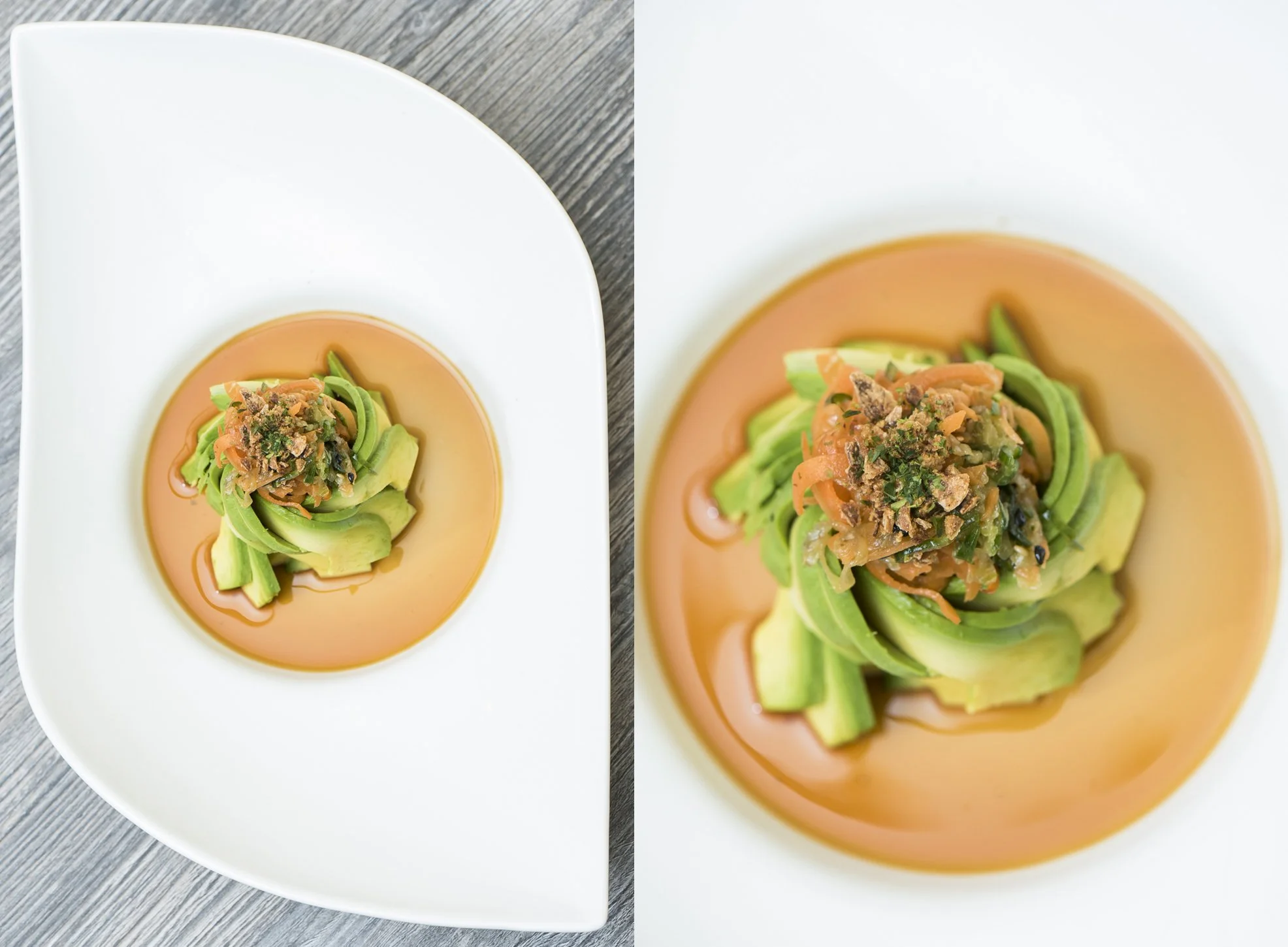 A white plate with a swirl of pinkish sauce, topped with spiralized cucumber and shredded carrots, garnished with chopped herbs and crumbled topping.