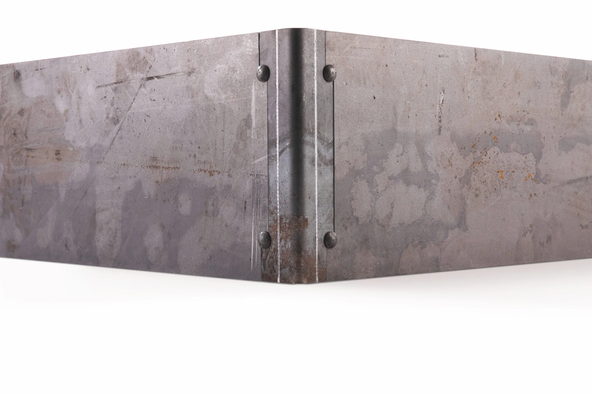 Close-up of a corner of a steel or concrete structure with visible bolts and a rusted seam.