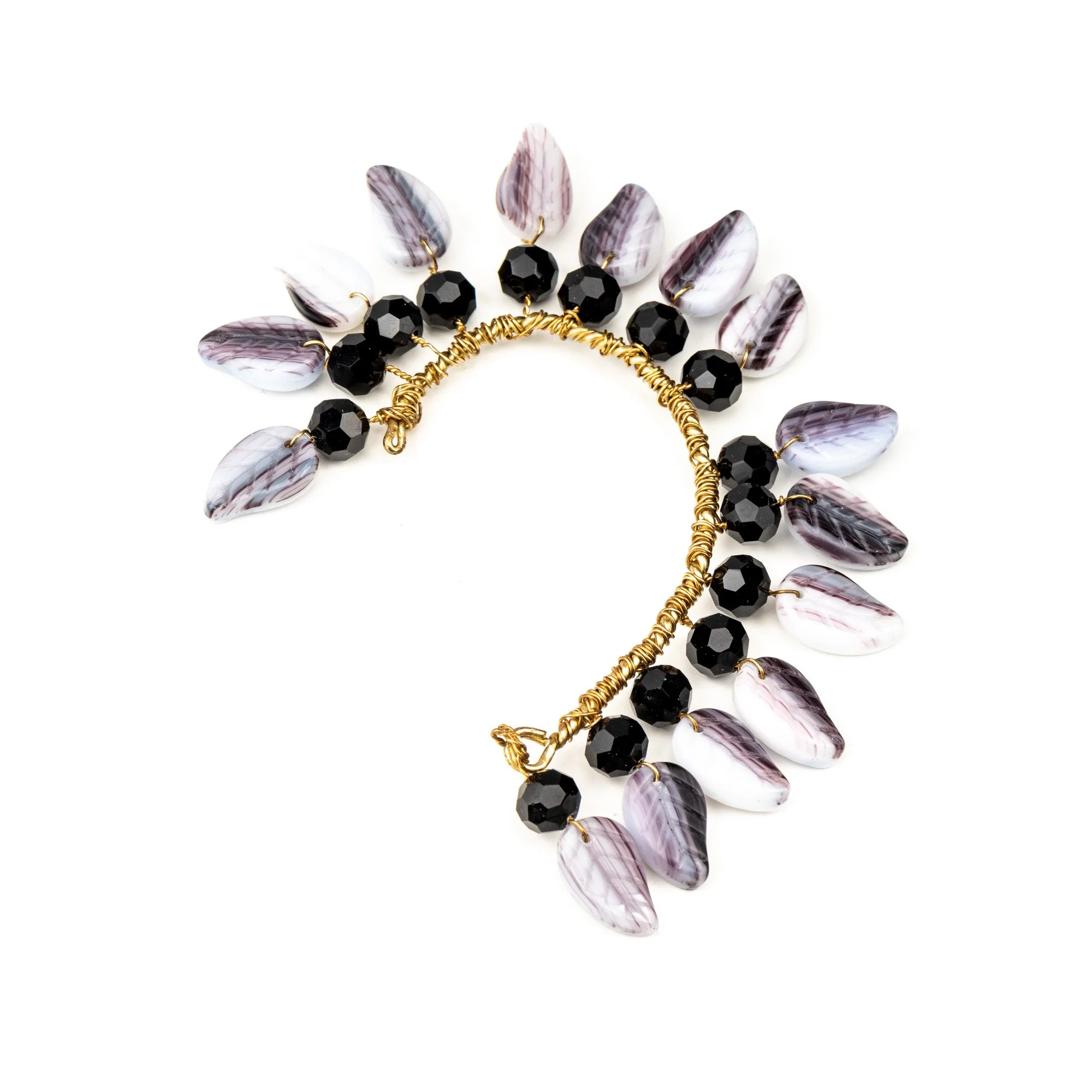 Bracelet with black faceted beads and purple striped teardrop-shaped beads on a gold chain.