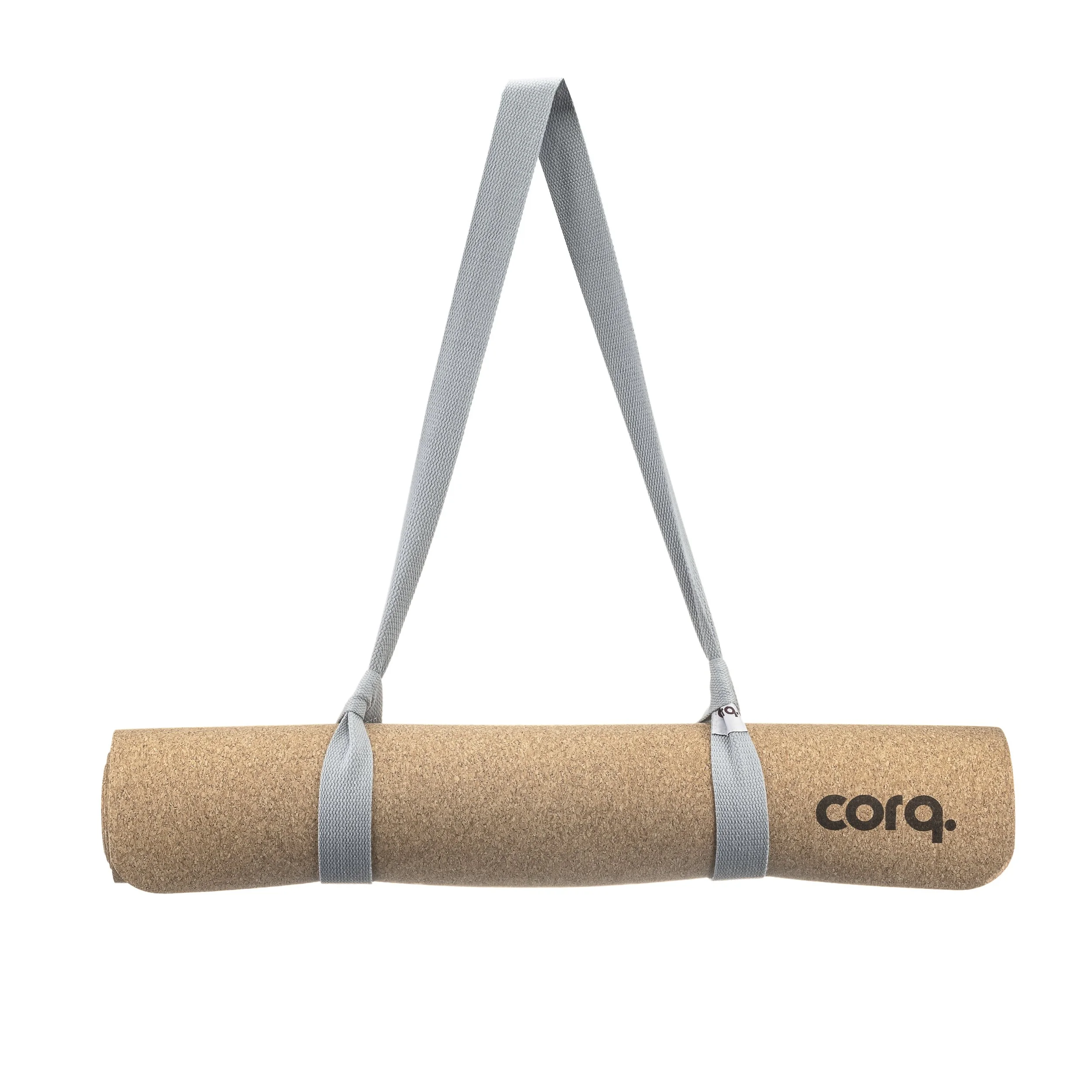 Cork yoga mat with gray straps hanging from a gray strap handle.