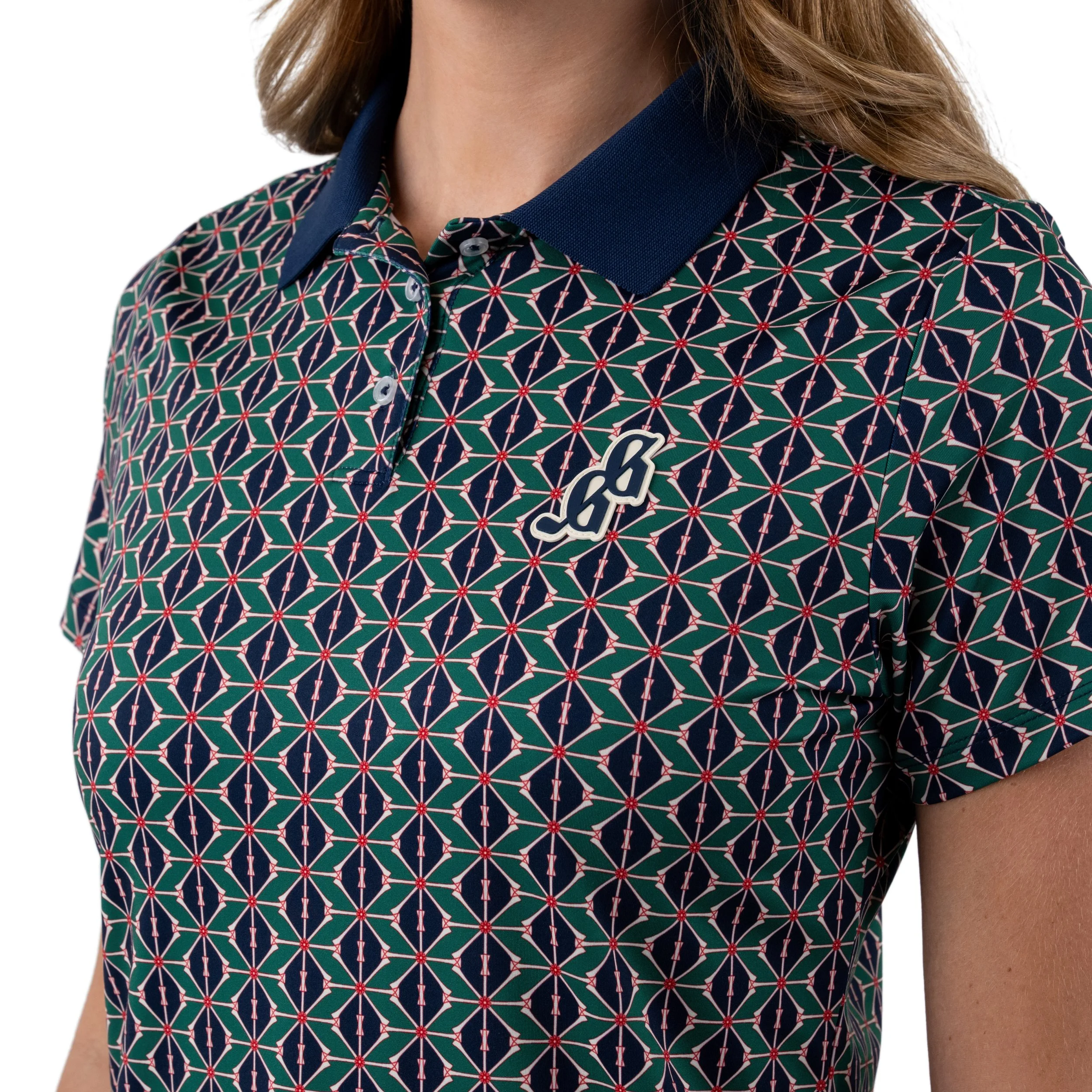 Close-up of a woman wearing a patterned golf shirt with a blue collar and an embroidered logo on the chest.