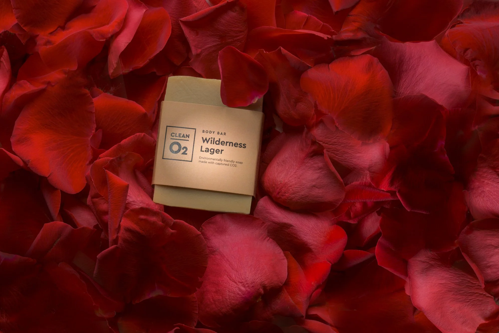 A beige and white package labeled 'Wilderness Lager' surrounded by red rose petals.