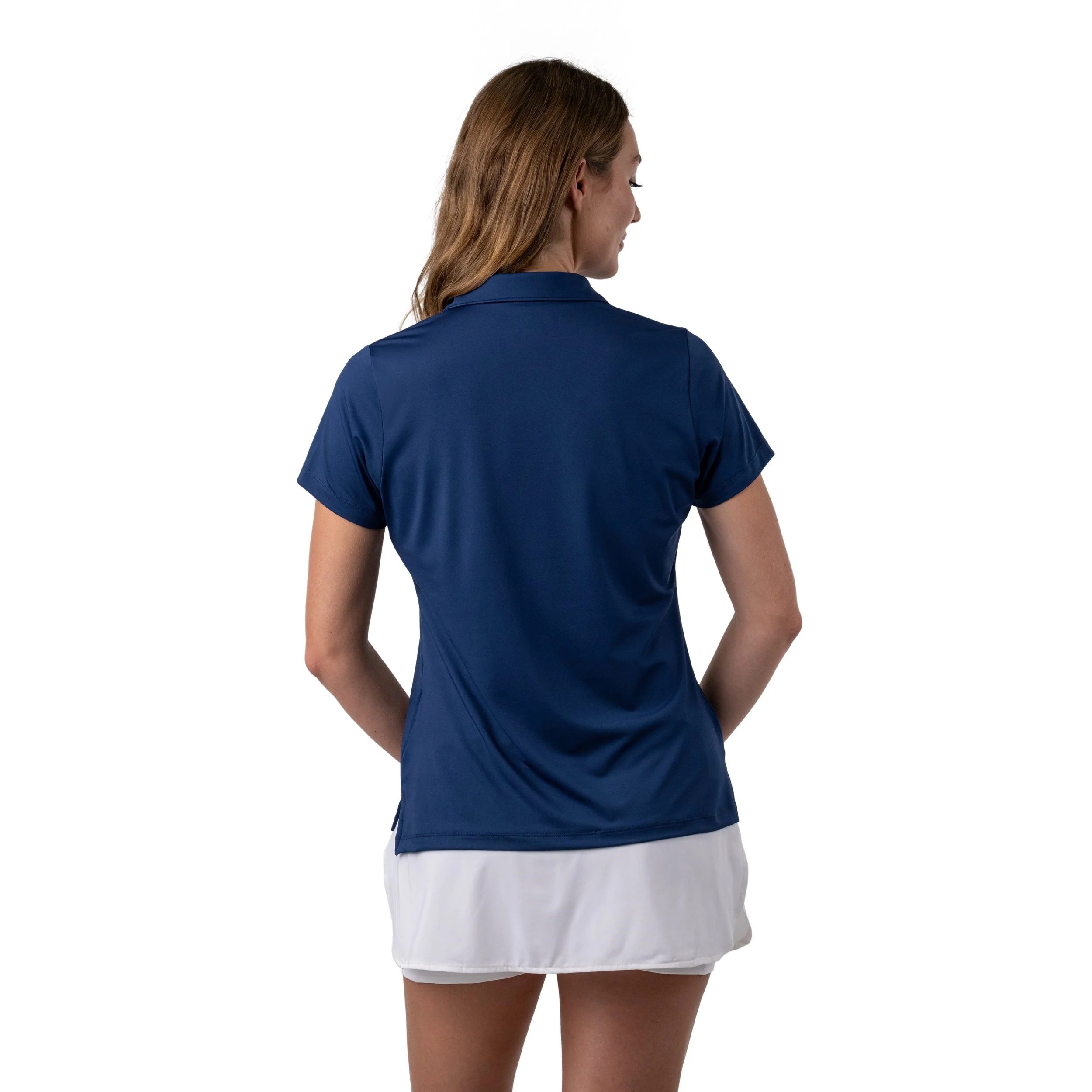Back view of a woman in a blue athletic polo shirt and white tennis skirt.