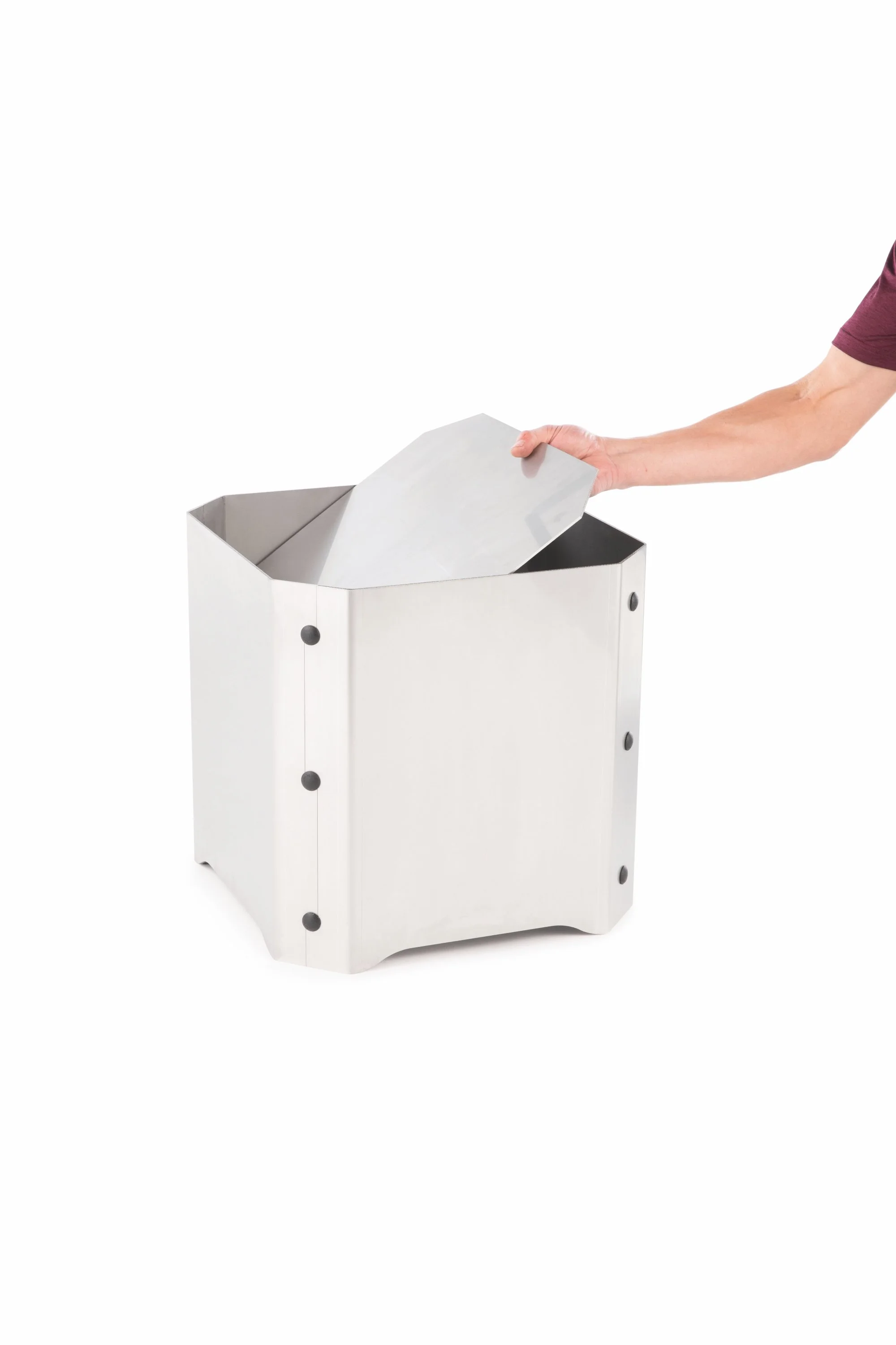 A person putting a piece of paper into a modern, white stainless steel trash or recycling bin.
