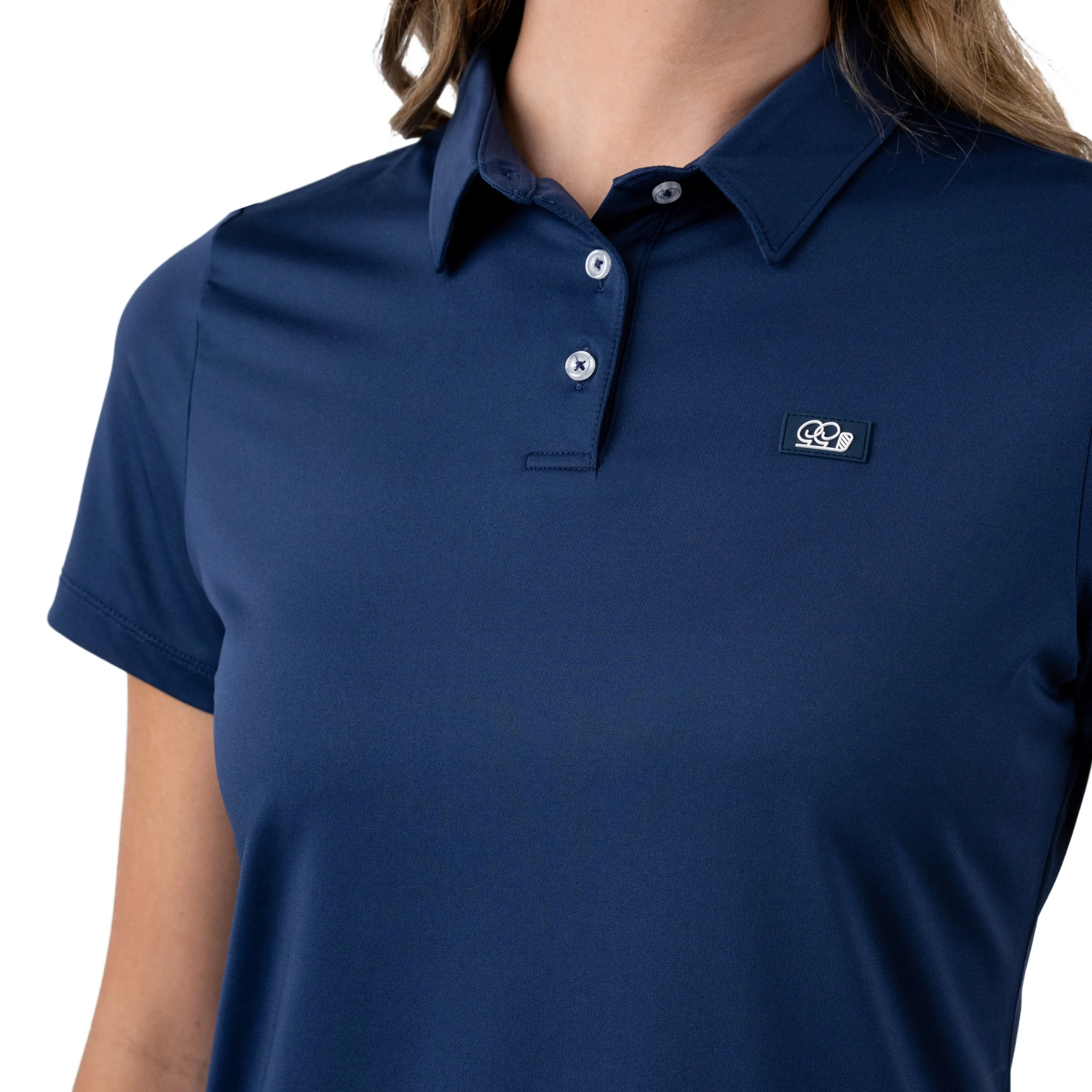 Close-up of a woman wearing a navy blue polo shirt with a small logo on the left chest area.