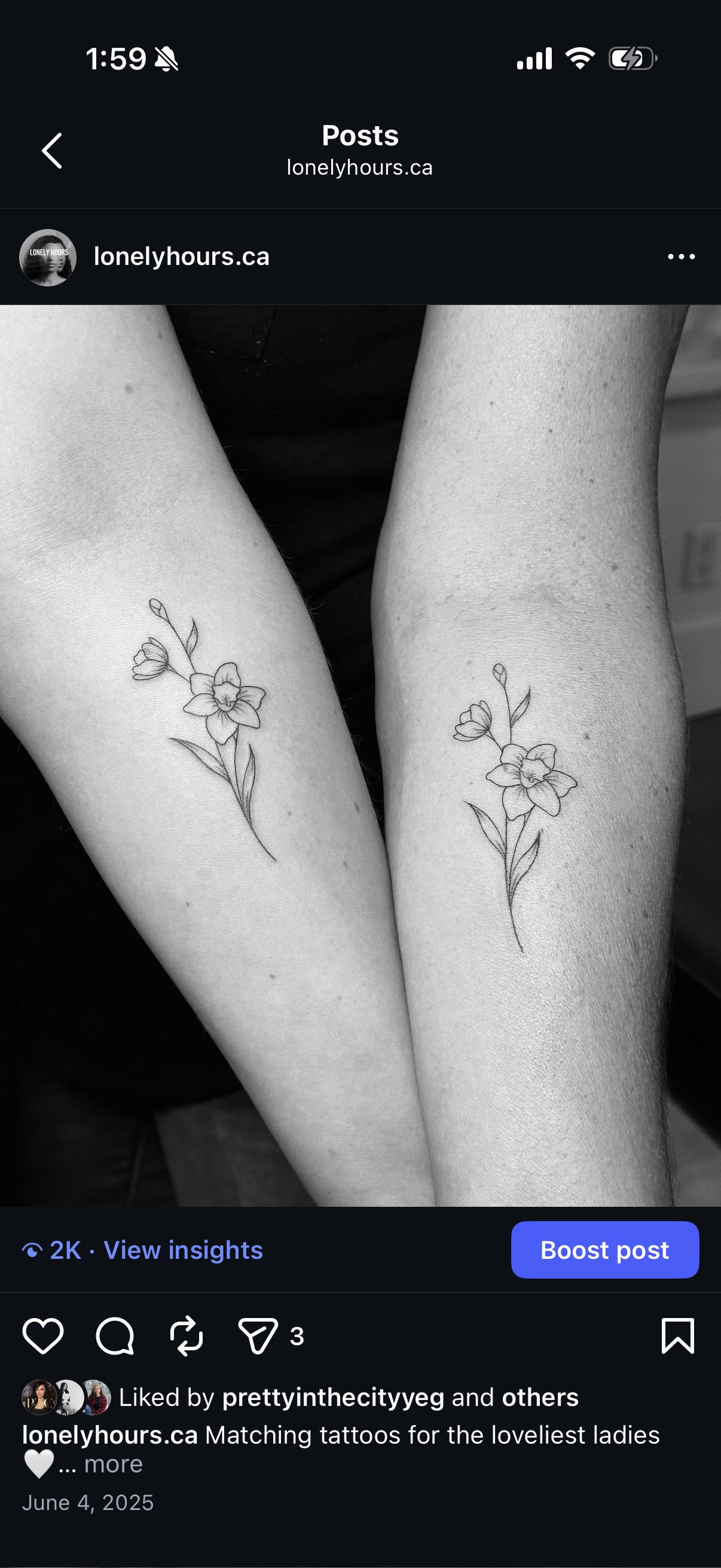 Black and white photo of two arms with matching floral tattoos on the forearms. The tattoos feature a delicate flower with leaves and a small bud on a thin stem.