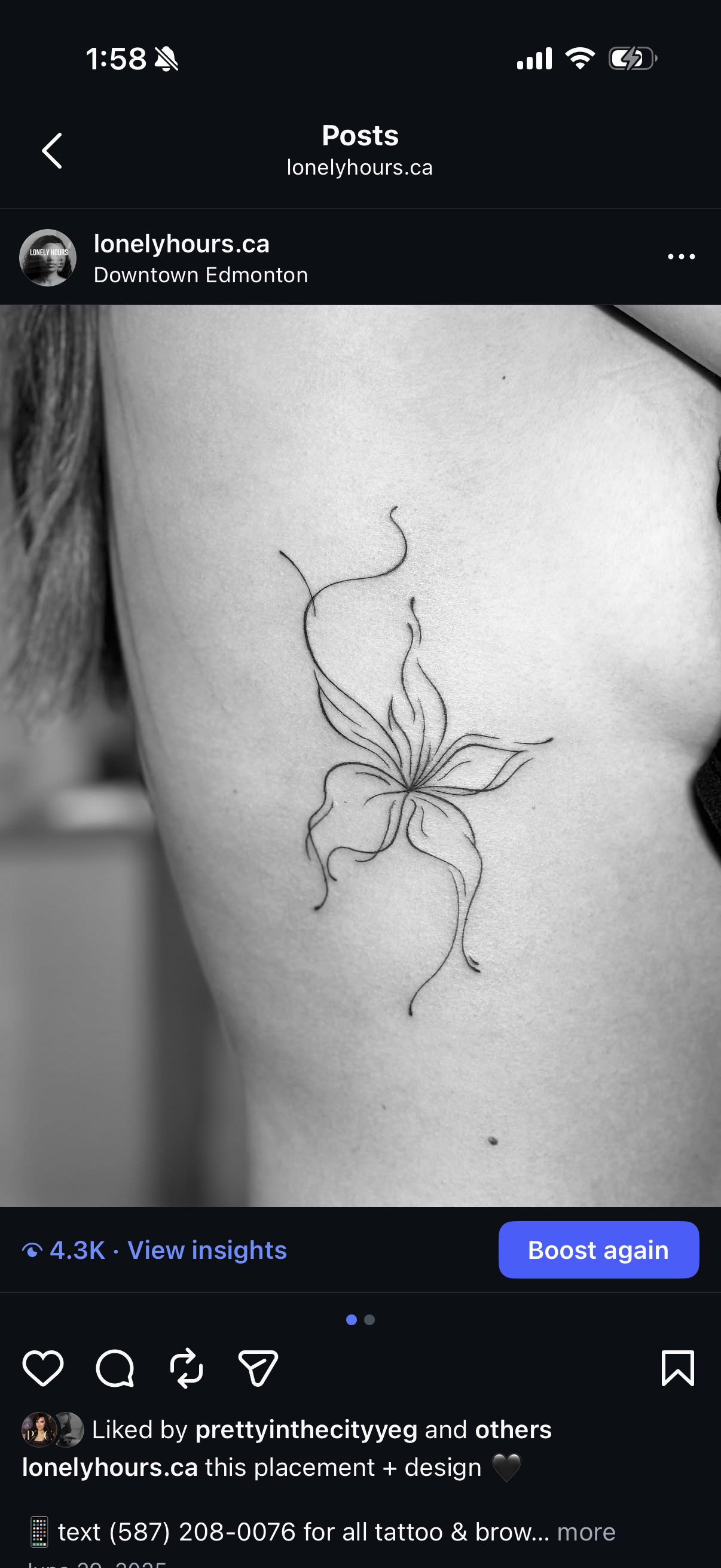 Close-up of a person's side torso with a delicate black ink tattoo of a flower with flowing, curving lines.