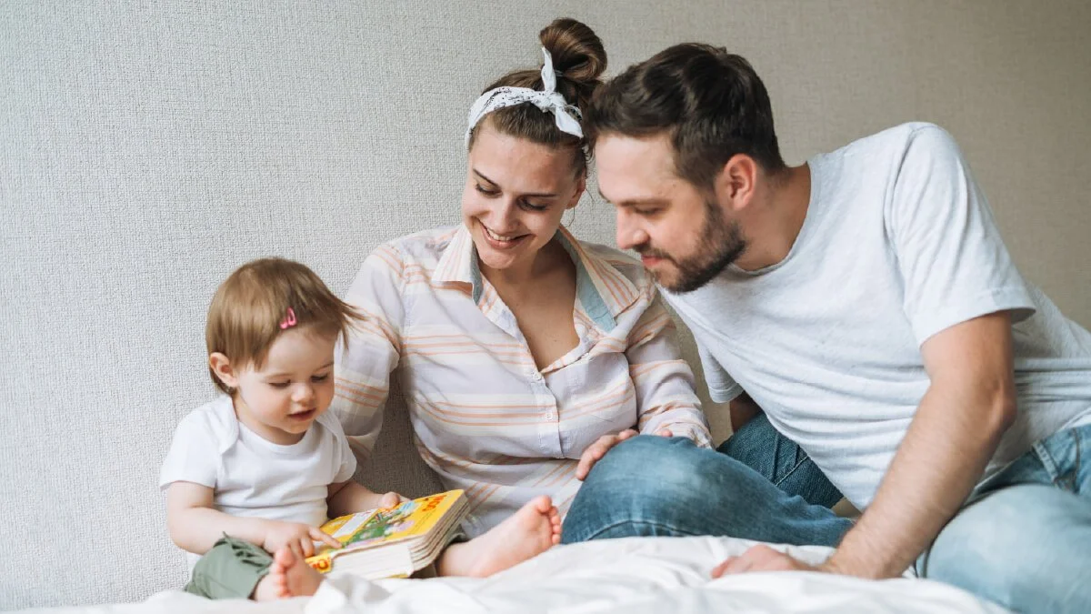 Parents reading a book with their toddler while supporting early literacy, language development, and family bonding