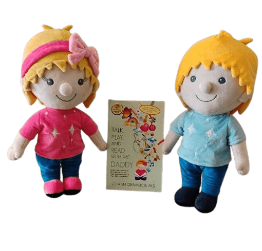 Two stuffed plush dolls, Ruby and Louie, with blonde hair, one wearing a pink shirt and the other a blue shirt, positioned on either side of a children's book titled 'Talk, Play, and Read With Me Daddy' against a black background.