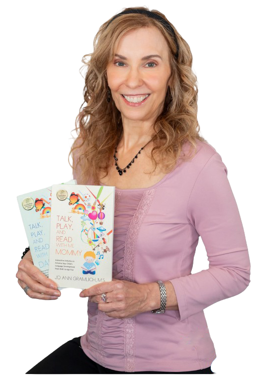 A woman Jo Ann Gramlich with curly blonde hair and a warm smile, wearing a lavender top with lace details, holding a colorful children's book titled 'Talk, Play, and Read With Me'