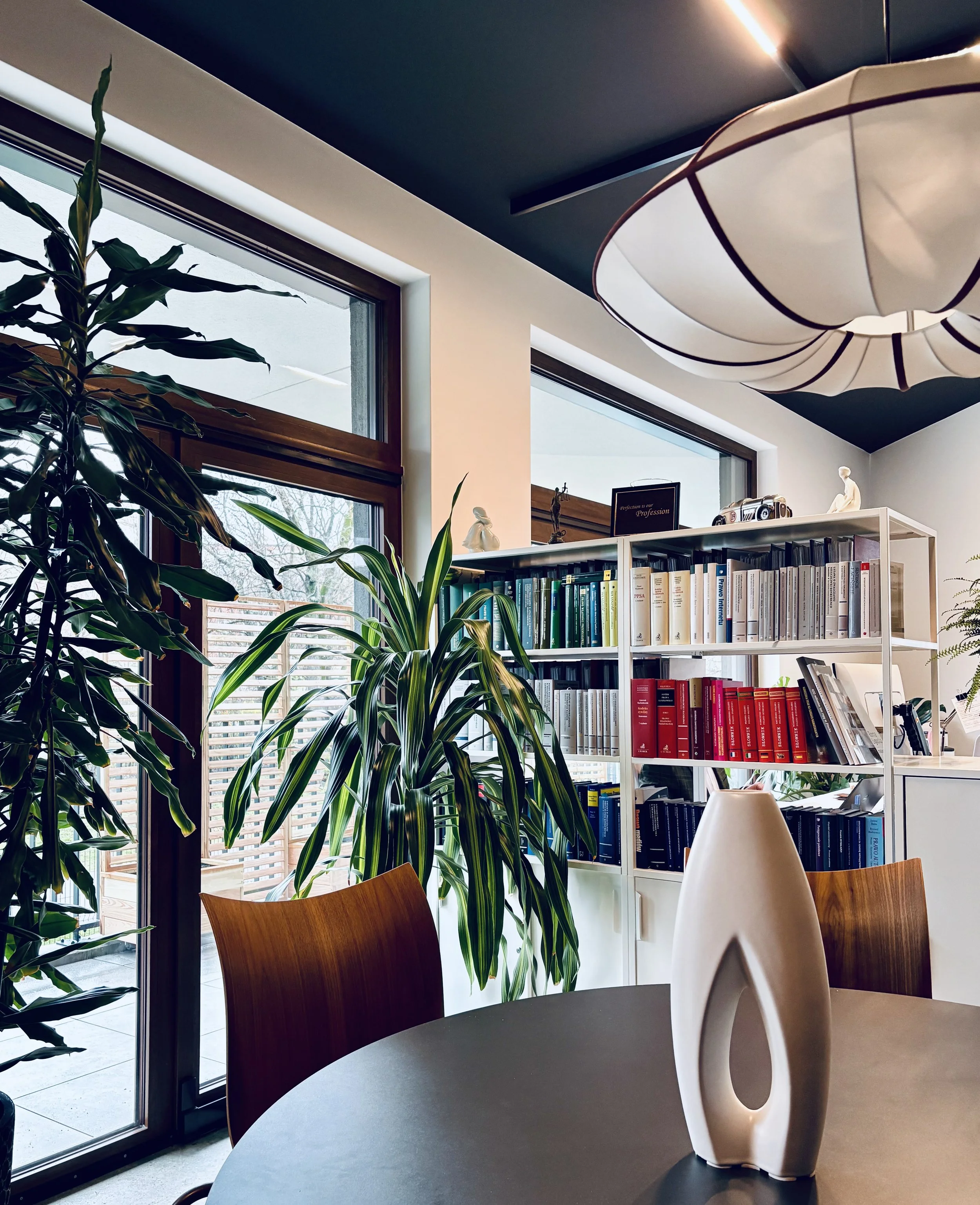 Półka z literaturą prawniczą posortowaną według kolorów w biurze KNM