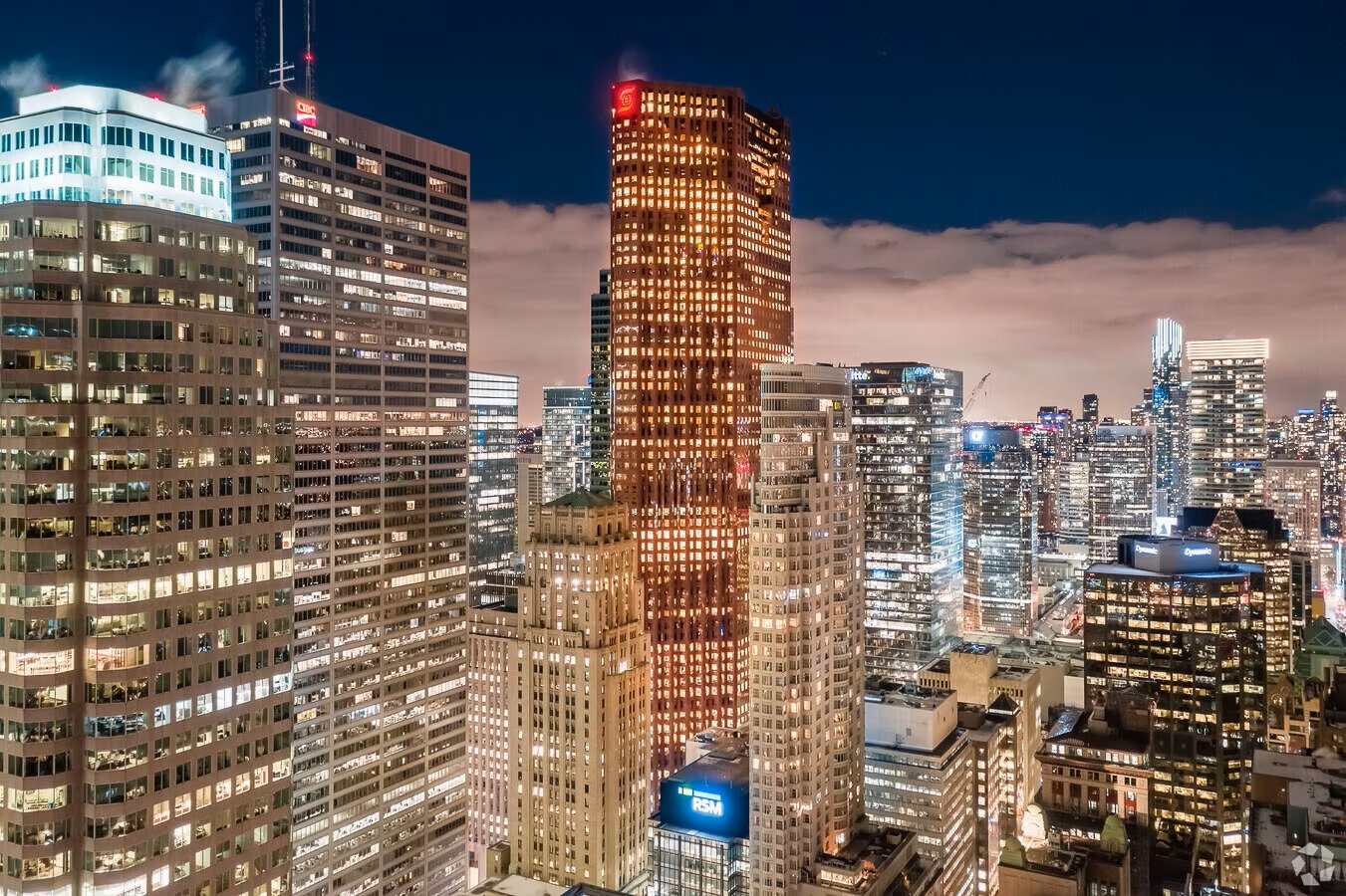 Night skyline of a city with tall illuminated skyscrapers and buildings.