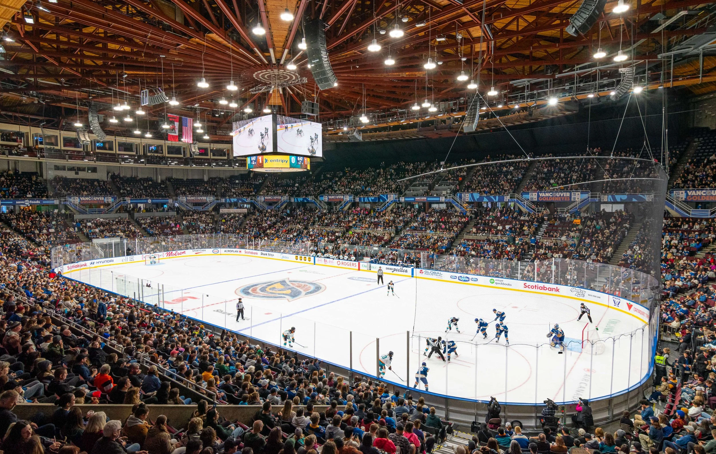 An indoor ice hockey game with players on the ice and an audience in the stands at Rogers Arena in Vancouver.