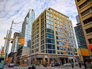 City street scene with tall buildings, traffic lights, and vehicles.