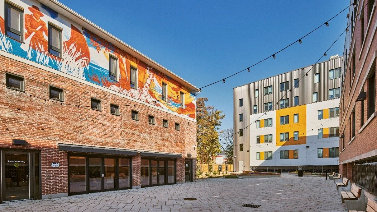 A renewed historic building stands next to a brand new building, both providing housing in Hamilton.