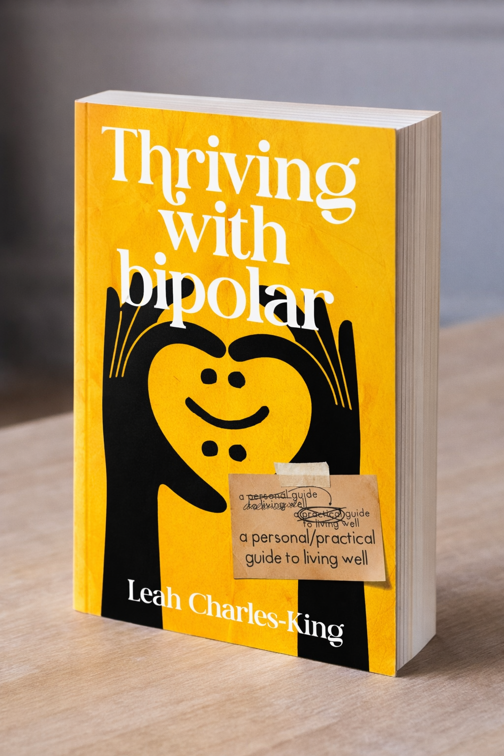 A yellow book titled 'Thriving with Bipolar' by Leah Charles-King. Leah Charles-King is a TV Presenter, Black mental health advocate, author, speaker, female activist,  and Bipolar UK ambassador
