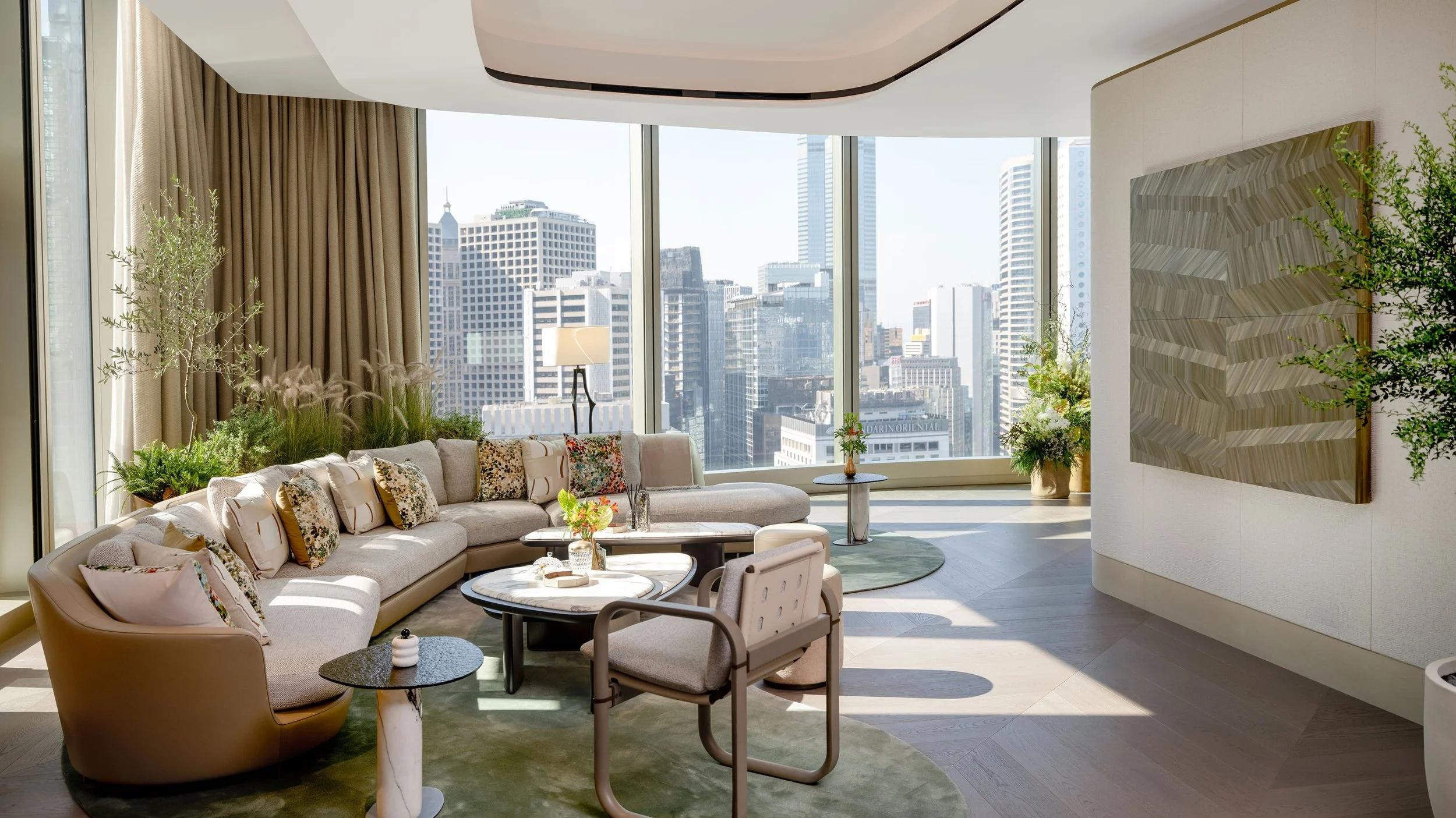 Bright lounge area inside the Audemars Piguet House at The Henderson in Hong Kong, featuring floor-to-ceiling windows, comfortable seating, and views of the surrounding skyscrapers.