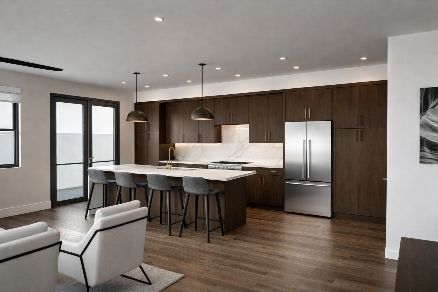 Modern kitchen with dark wood cabinets, stainless steel refrigerator, white marble backsplash, and an island with four gray barstools. Recessed and pendant lighting, light-colored walls, and hardwood floors.