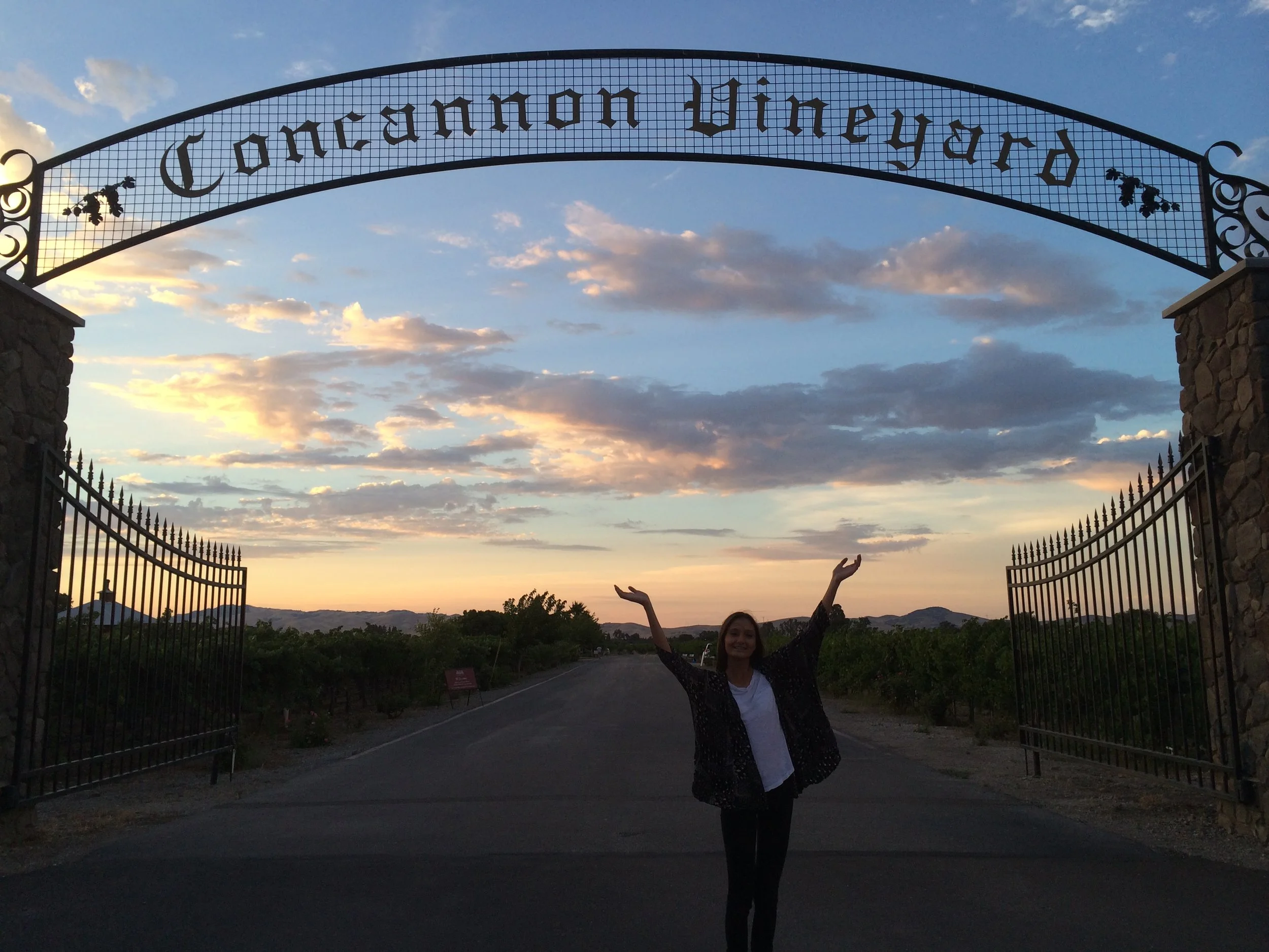 A woman posing under the Concannon Vineyard arch