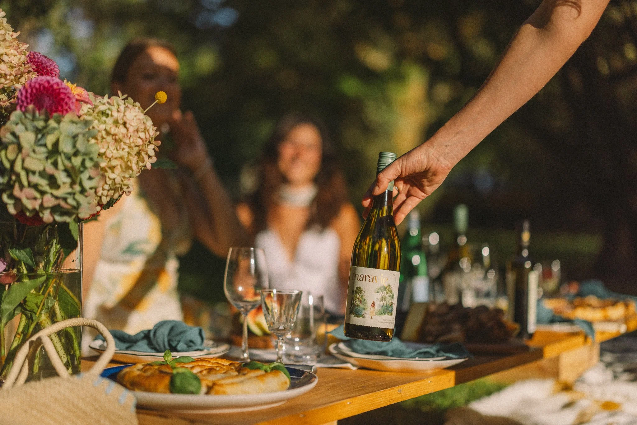 friends sharing chilled bottle of Marlborough Sauvignon Blanc at dinner